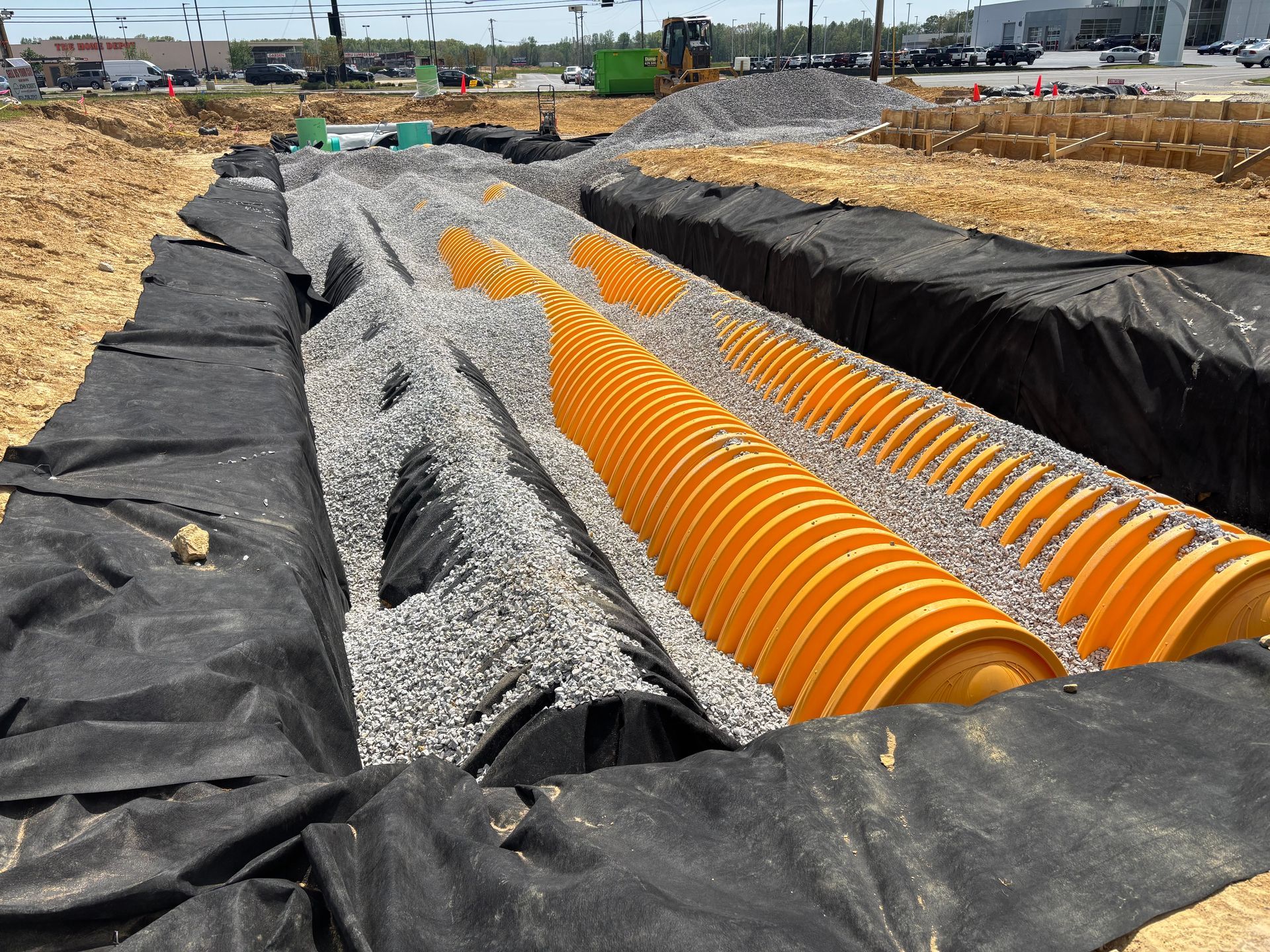 A large drainage system is being built in a dirt field.