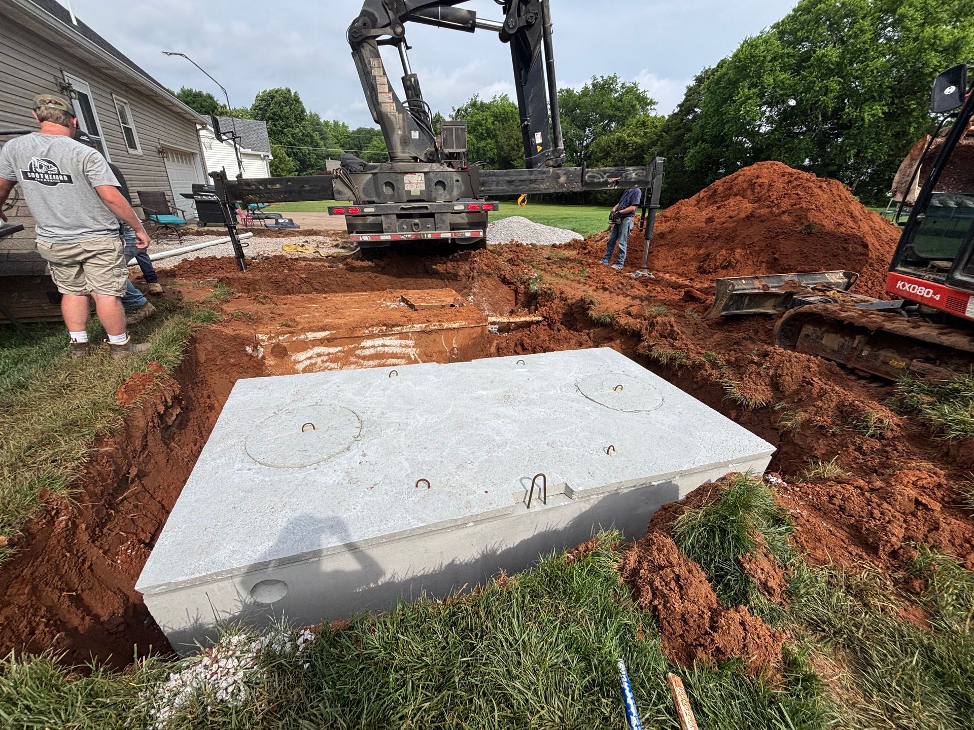 A man is standing next to a large concrete block in the dirt.