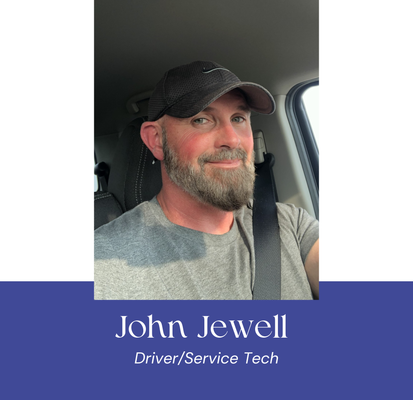 Man in a car, wearing a cap, with a gray beard and a seatbelt. Text reads 