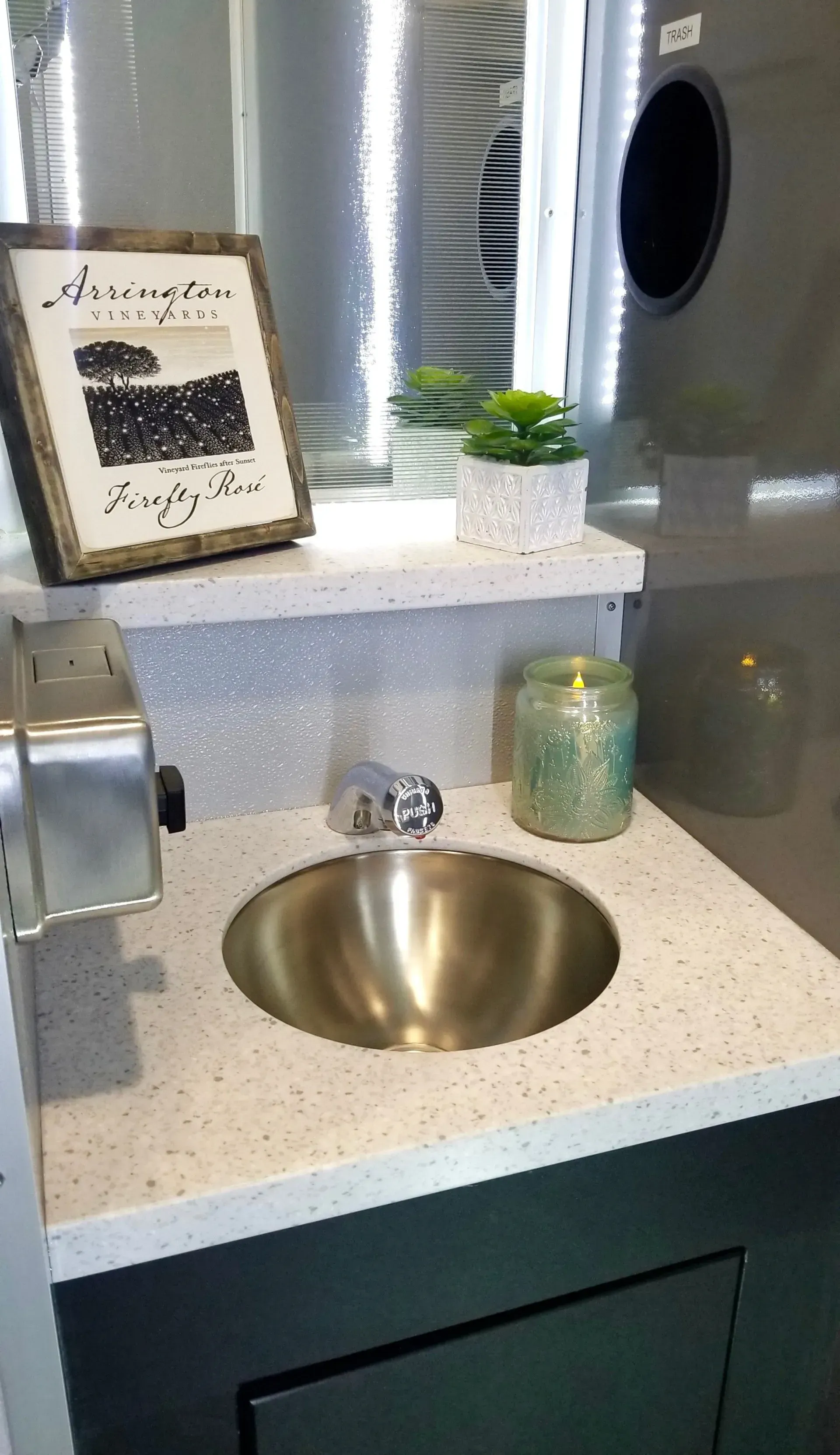 Bathroom sink with silver basin, glittery backsplash, and decorative items.