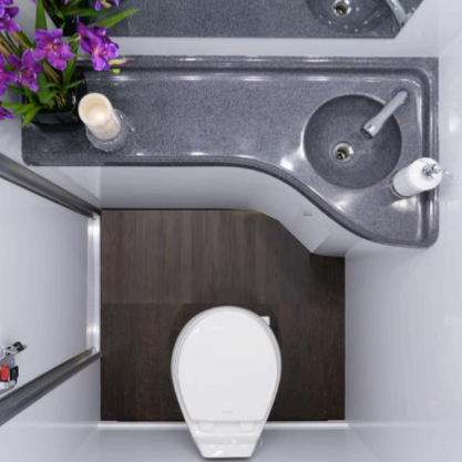 Top-down view of a small bathroom with gray countertop, sink, toilet, and a vase of purple flowers.