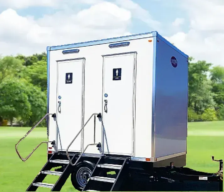 Portable restroom trailer with two separate stalls, white exterior, silver trim, and steps.