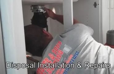 Person installs or repairs a garbage disposal under a kitchen sink.