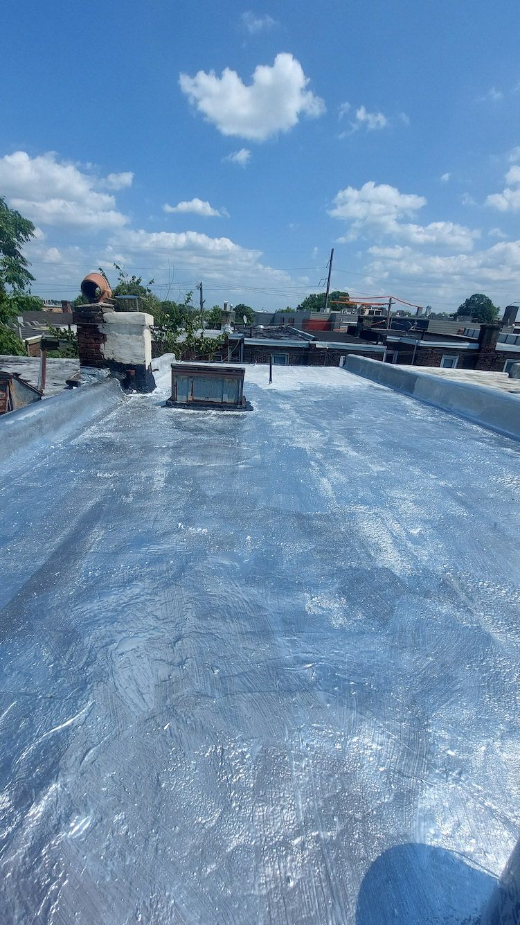 Blue tarpaulin-covered rooftop with a person working near the left side under a cloudy sky