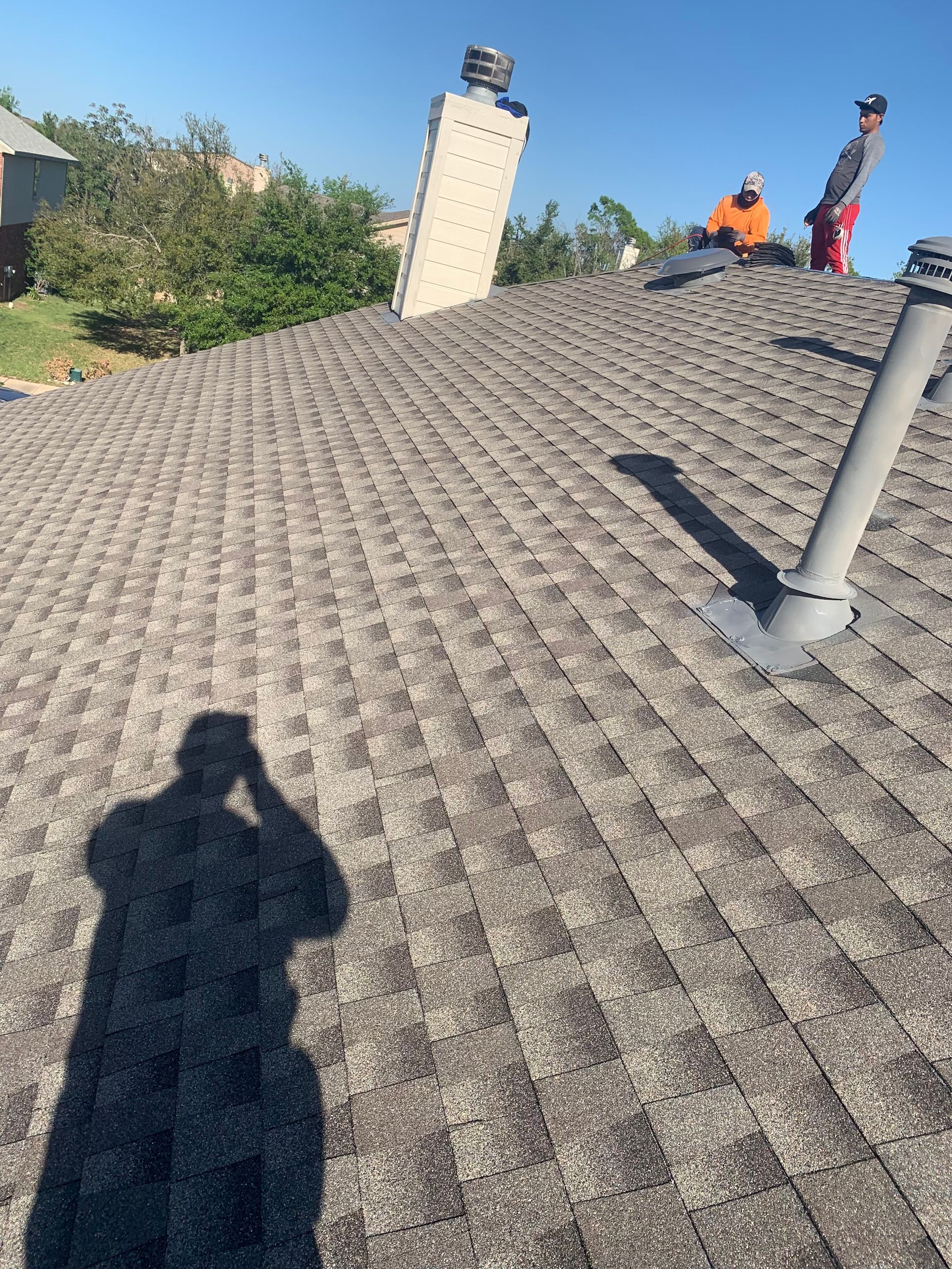 a shadow of a person is cast on the roof of a house