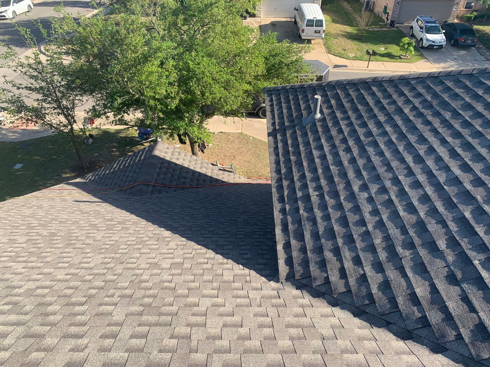 an aerial view of a roof of a house with a van parked in the driveway .