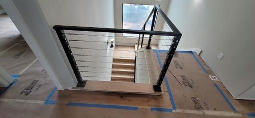 a staircase with a black railing is being built in a house .