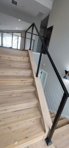 a wooden staircase with a glass railing in a house .
