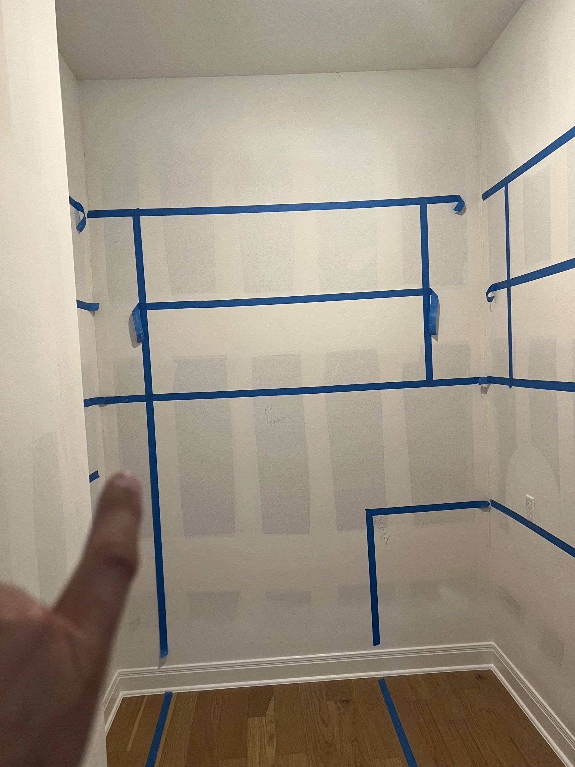 Wall with blue tape on it in the process of being painted