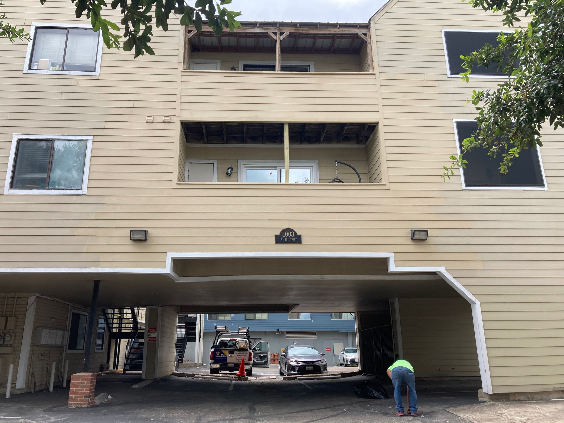 A building with a car parked underneath it.
