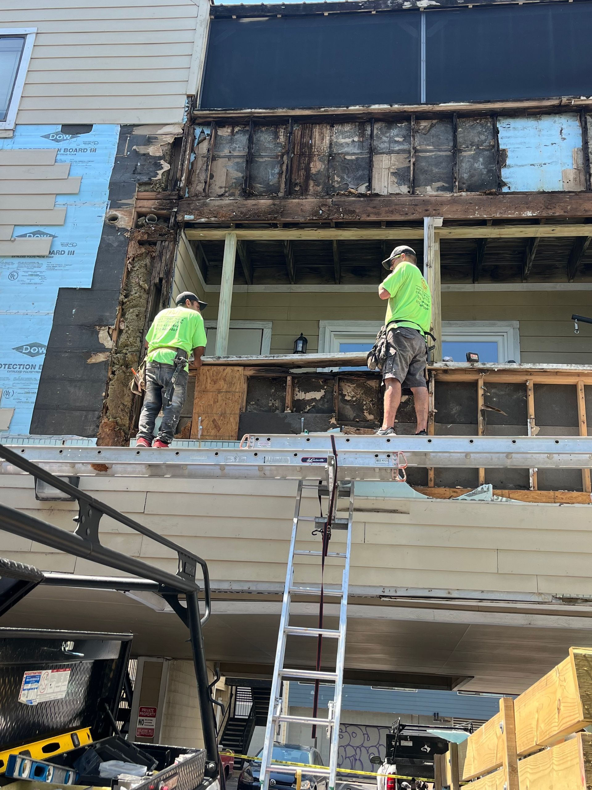 Two men are working on the roof of a house.