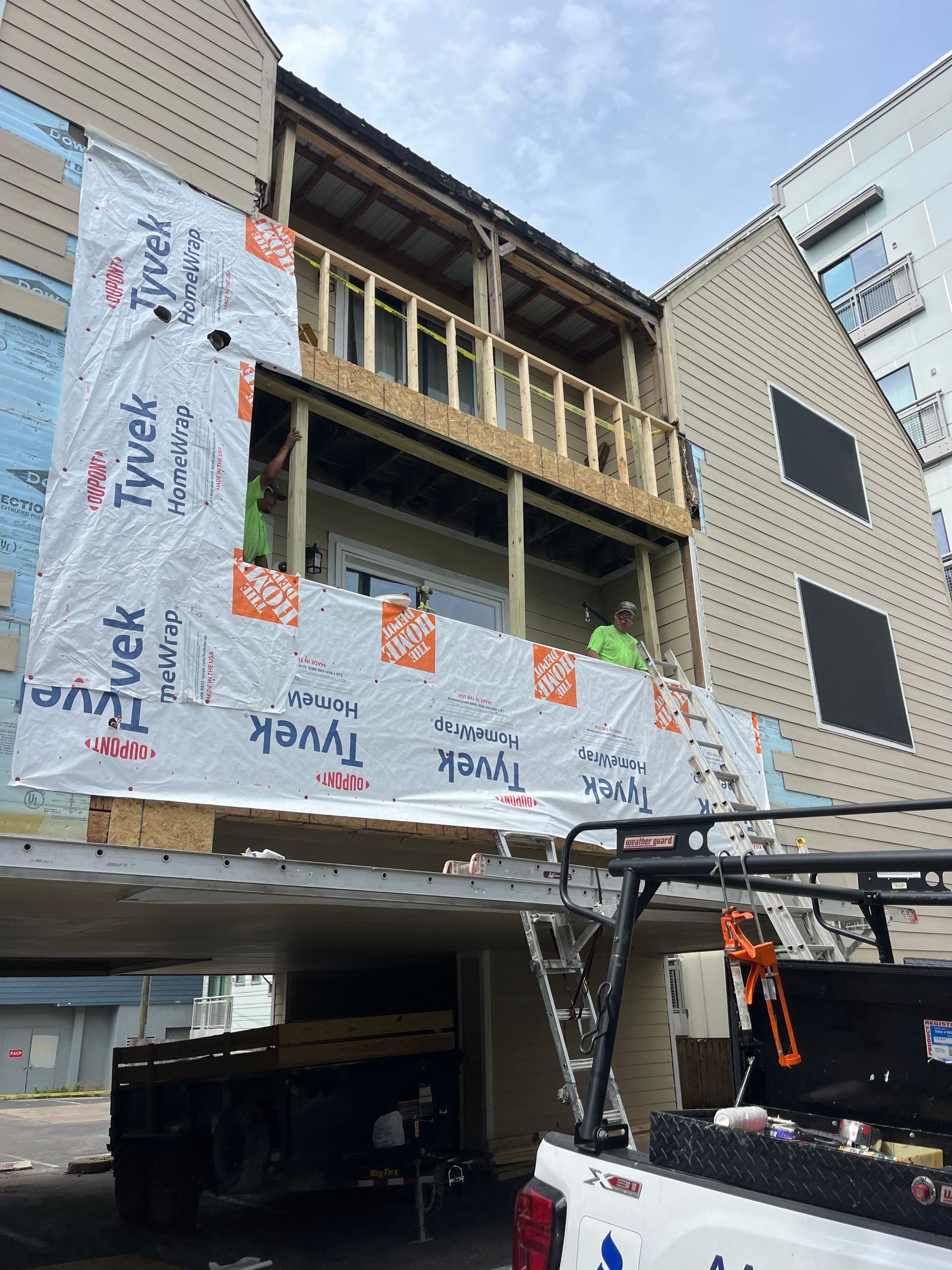 A truck is parked in front of a building under construction.