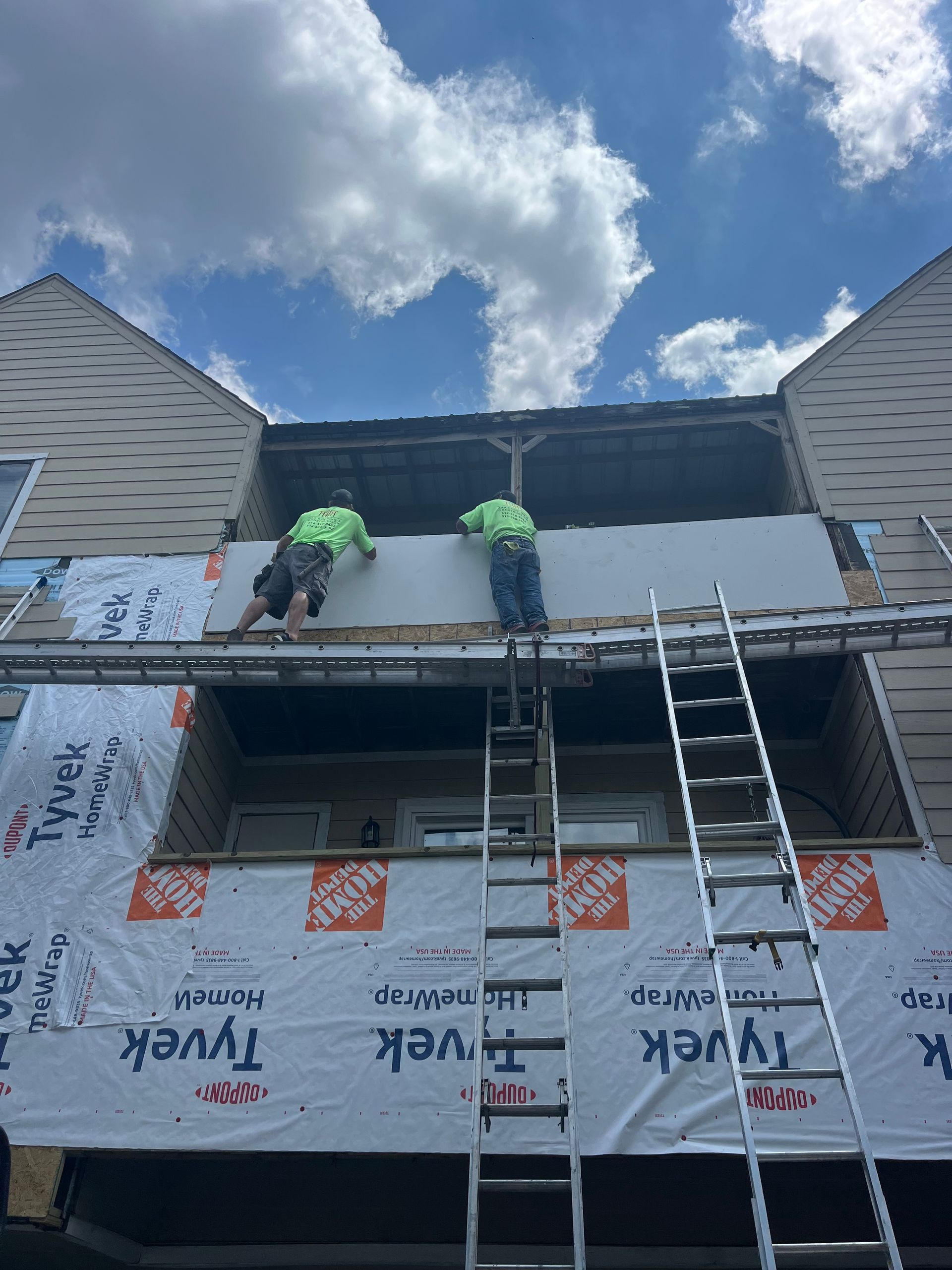 Two men are working on the roof of a building.