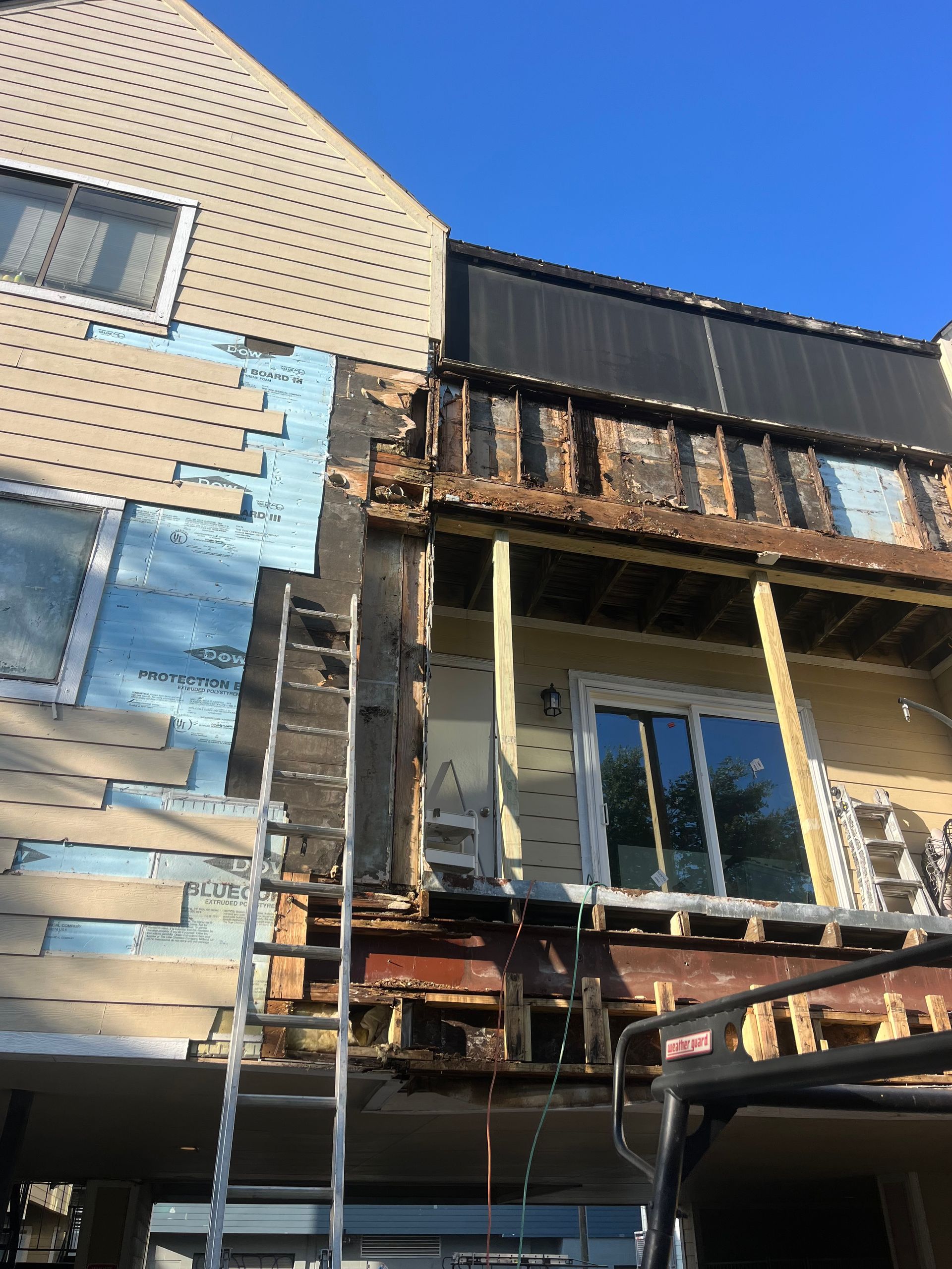 A ladder is sitting on the side of a house under construction.