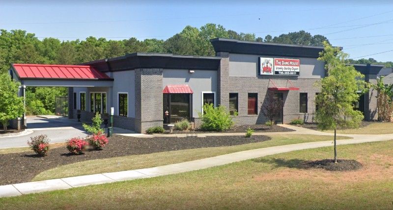 A large brick building with a red awning on the side of it.