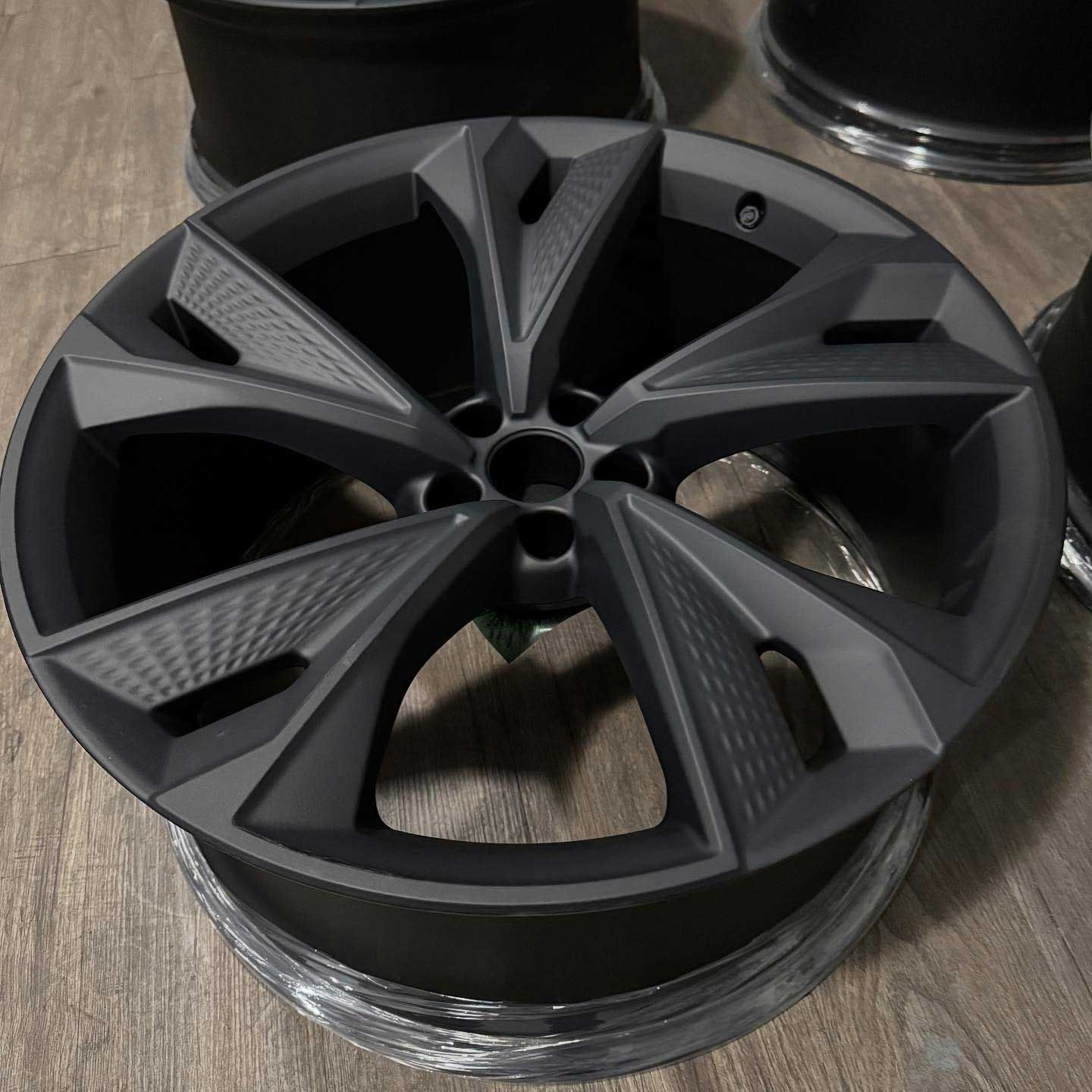 Dark gray alloy wheel with geometric spoke design.