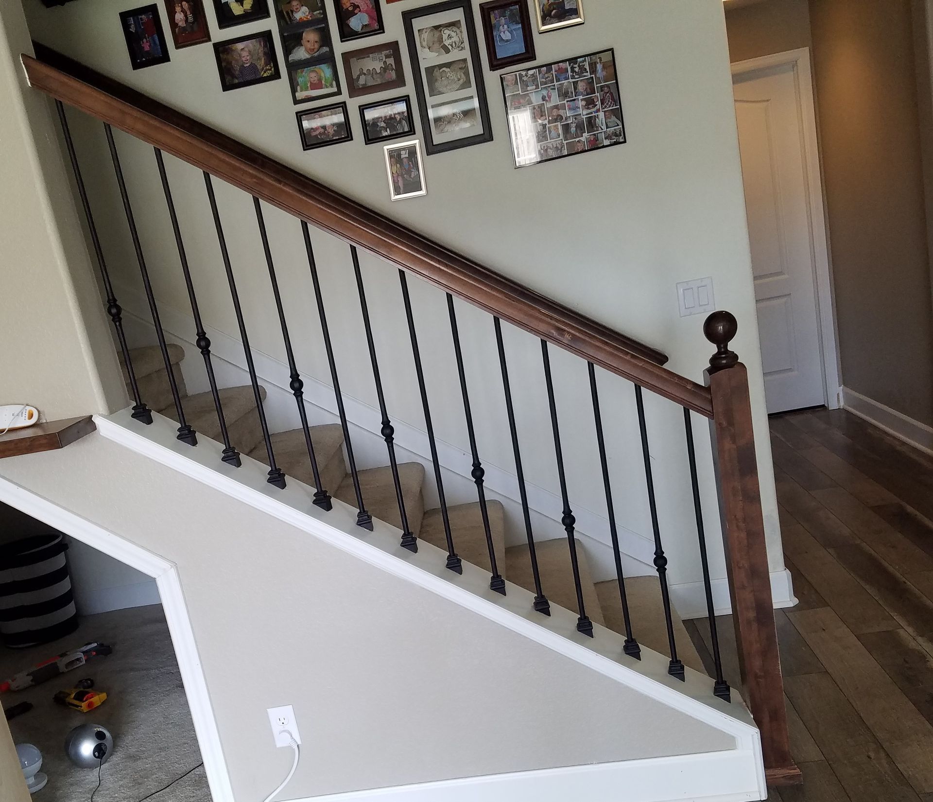 A staircase with a wooden railing and a wrought iron railing in a house.