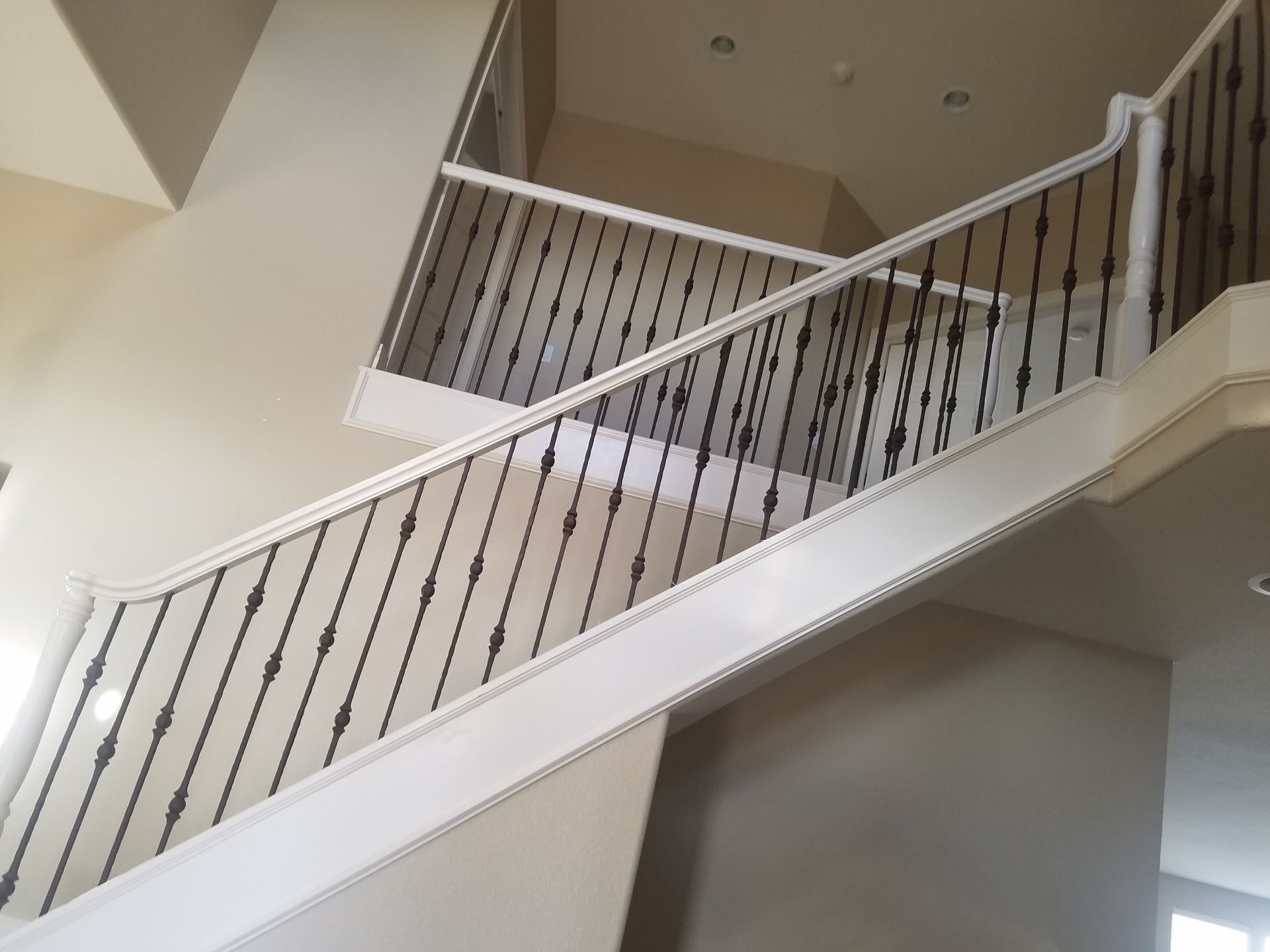 A white staircase with a black railing in a house