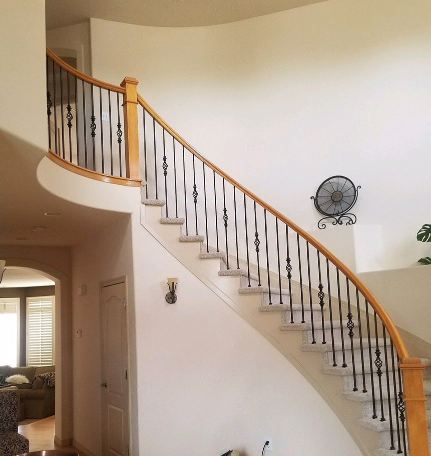 A curved staircase in a house with a fan on the wall