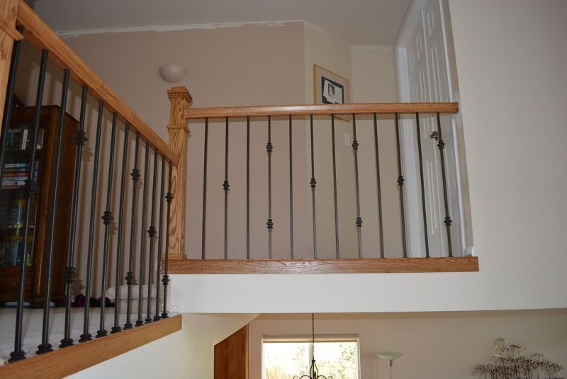 A staircase with a wooden railing and a wrought iron railing in a house.