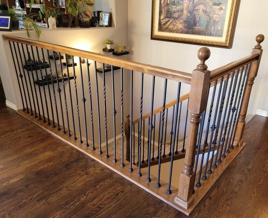 A wooden staircase with a wrought iron railing in a living room