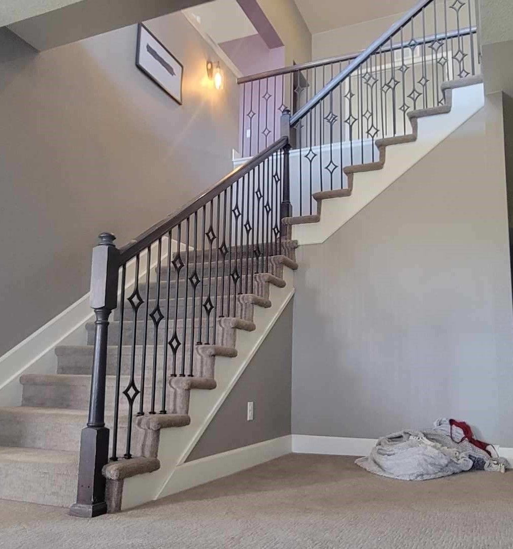 A staircase in a house with a wrought iron railing