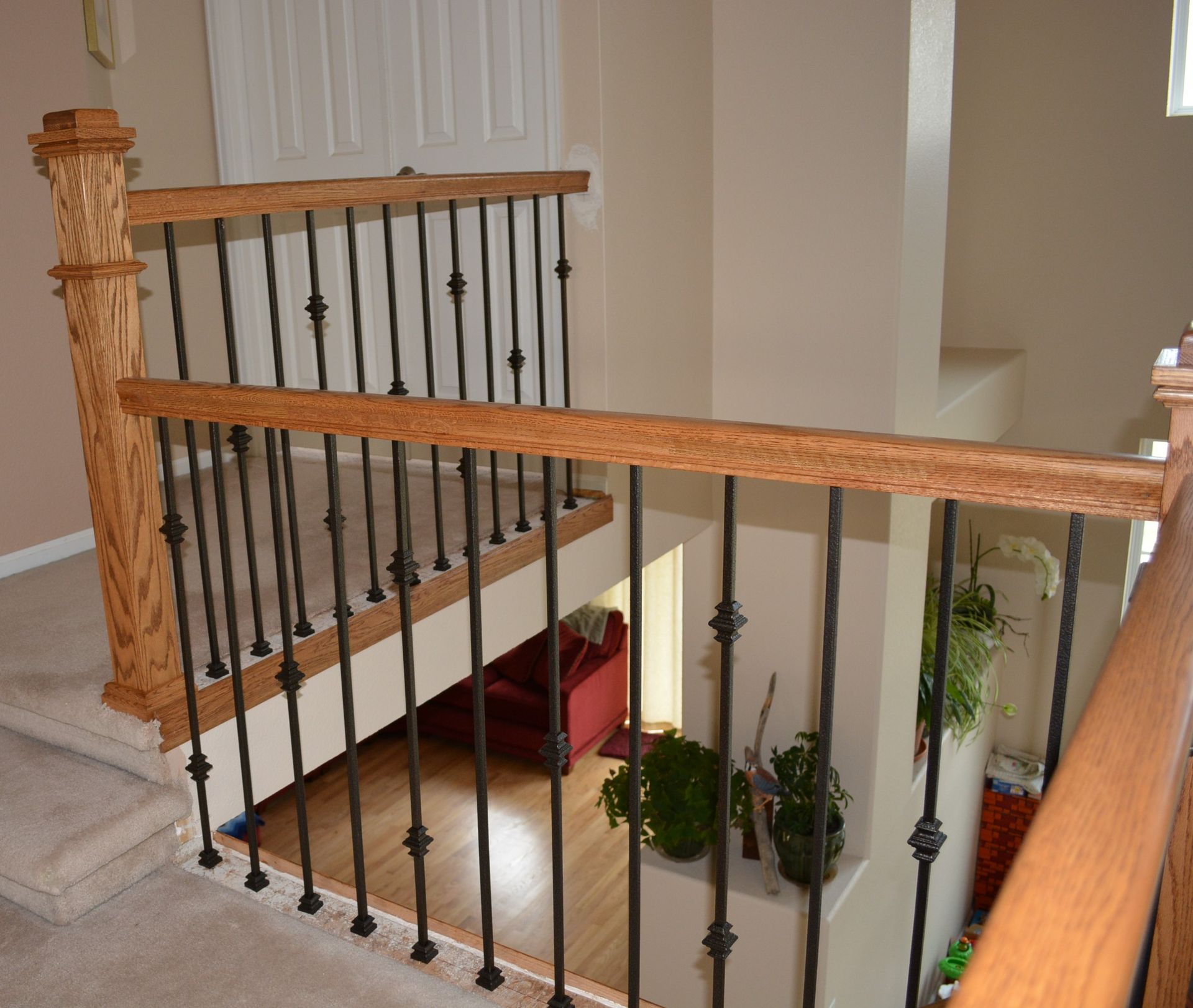 A staircase with a wrought iron railing and wooden handrail