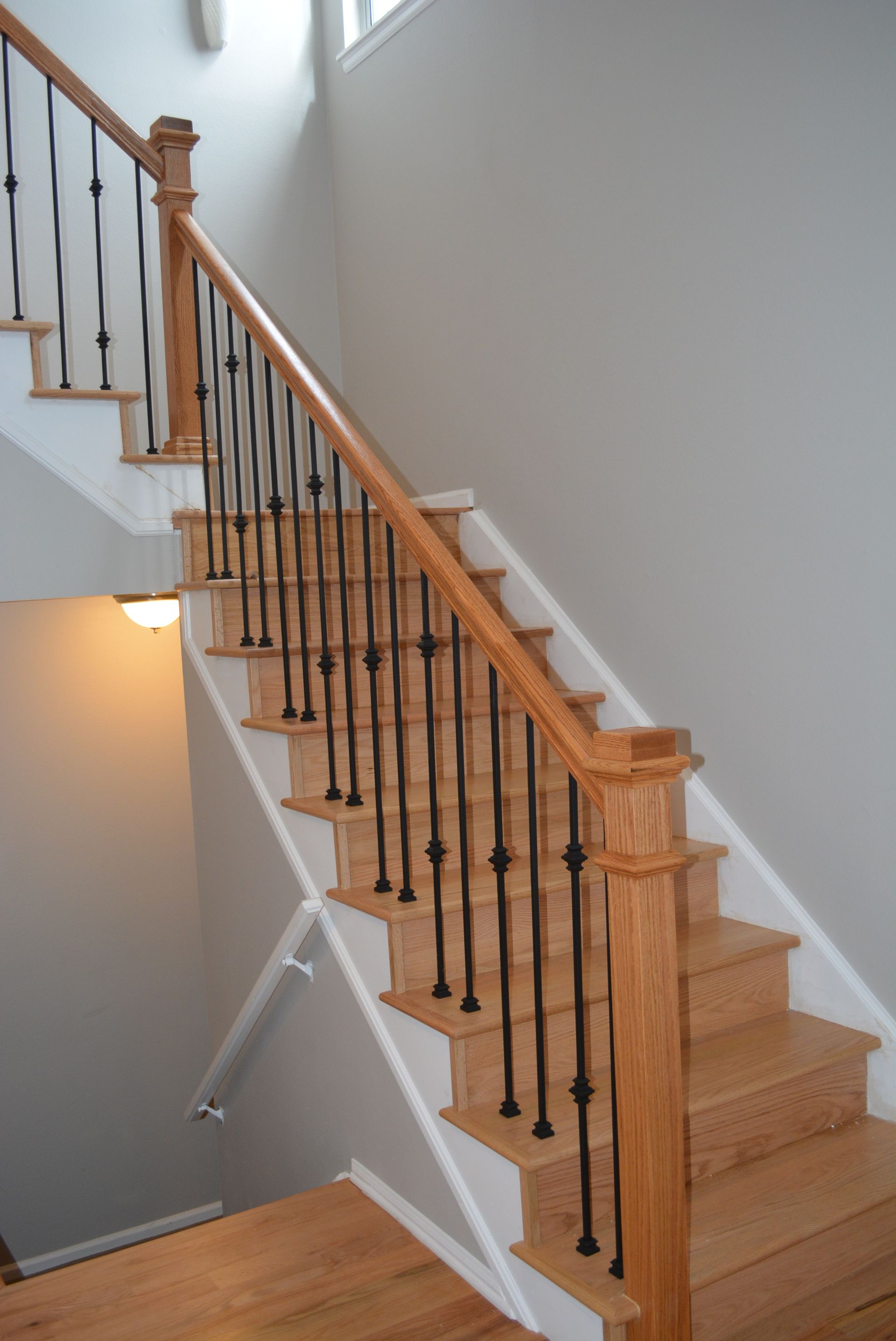 A wooden staircase with a black railing in a house.