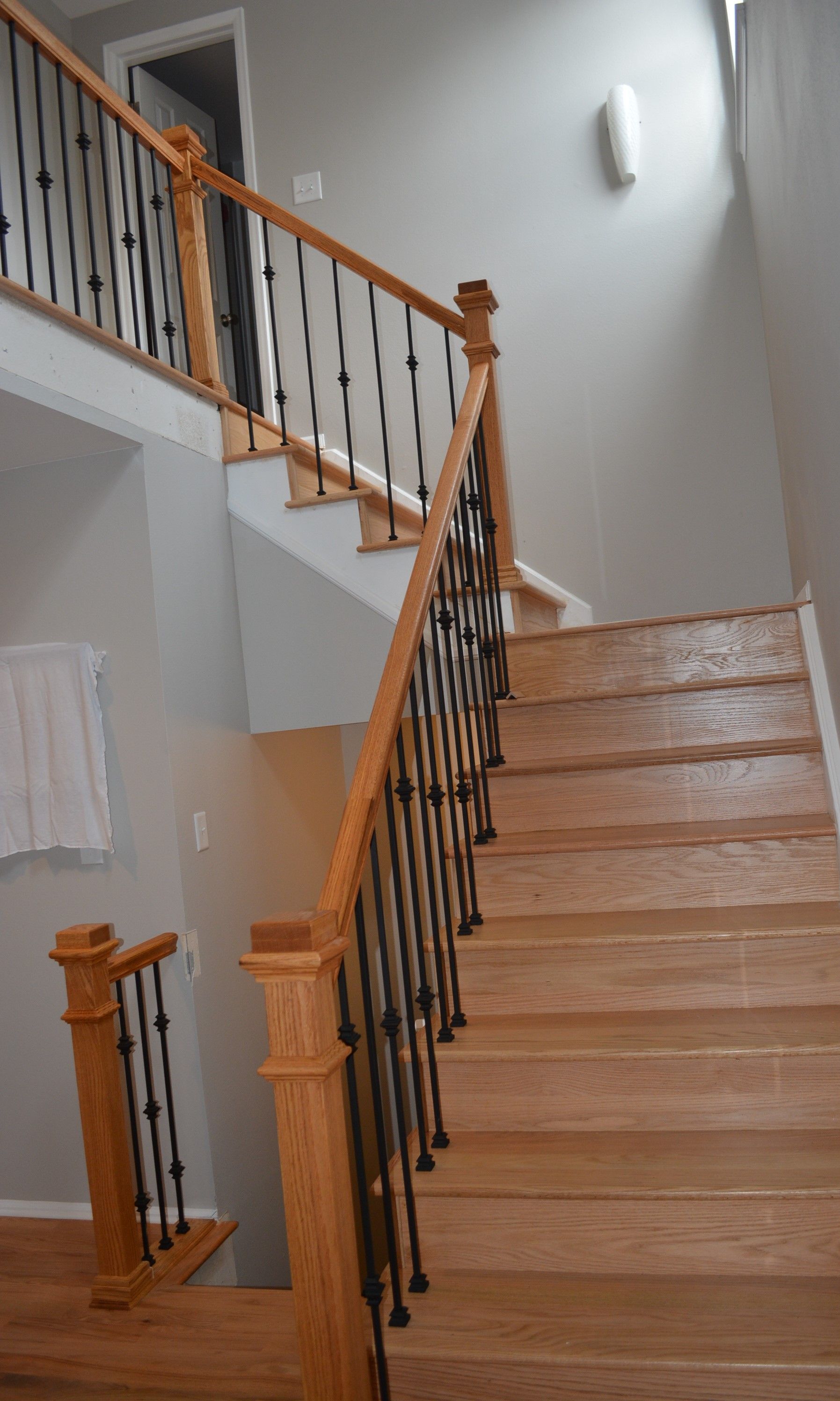 A wooden staircase with a wrought iron railing in a house