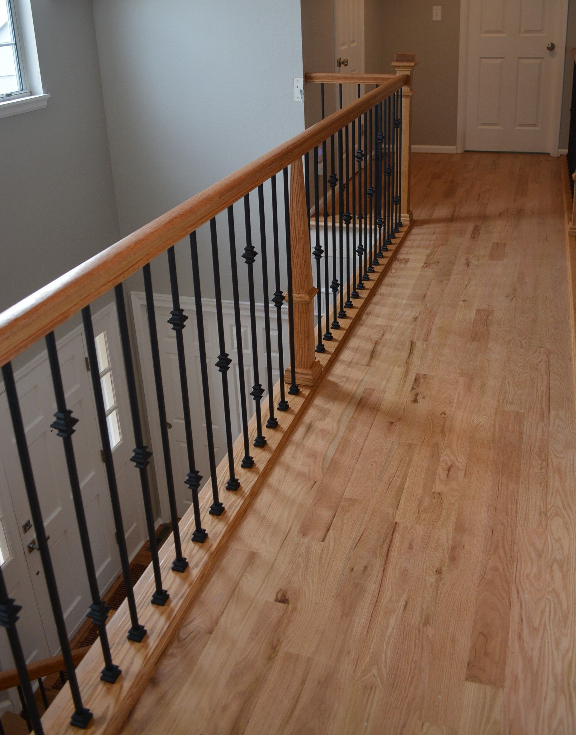 A wooden staircase with a wrought iron railing