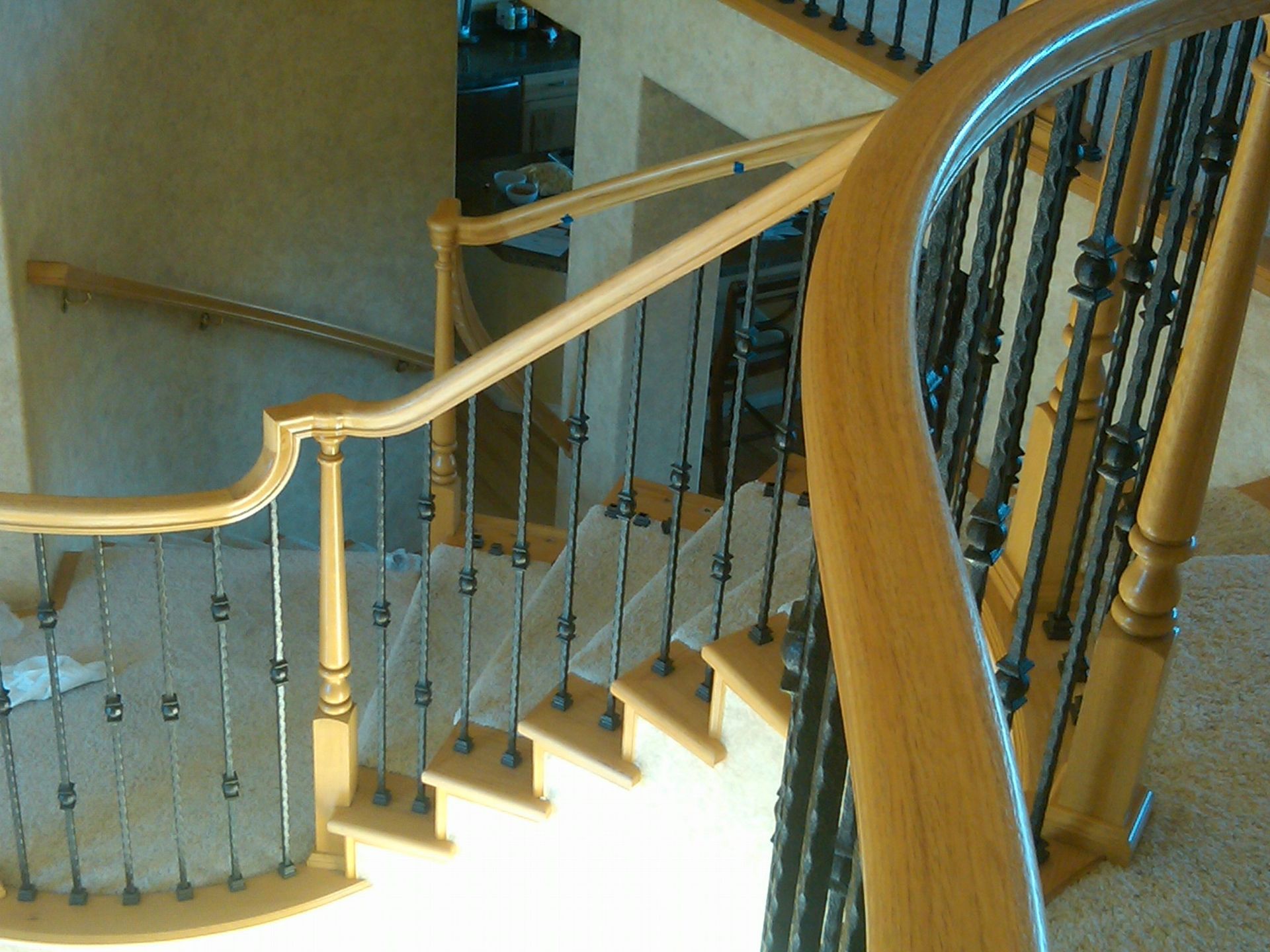 A staircase with a wooden railing and metal railings