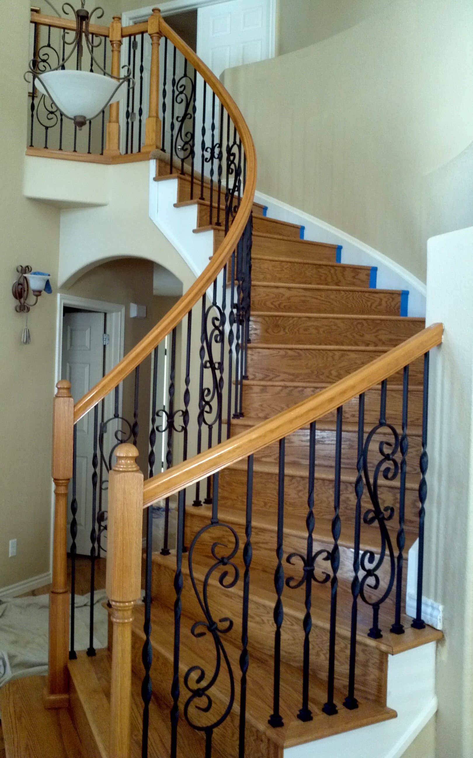 A spiral staircase with a wrought iron railing