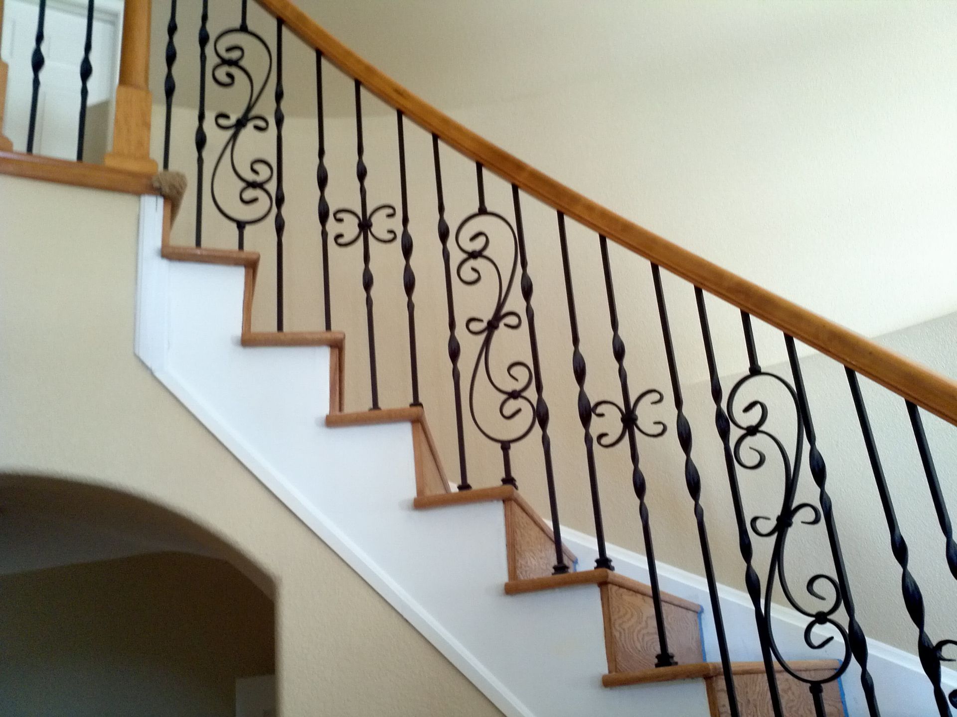 A staircase with a wrought iron railing and wooden steps