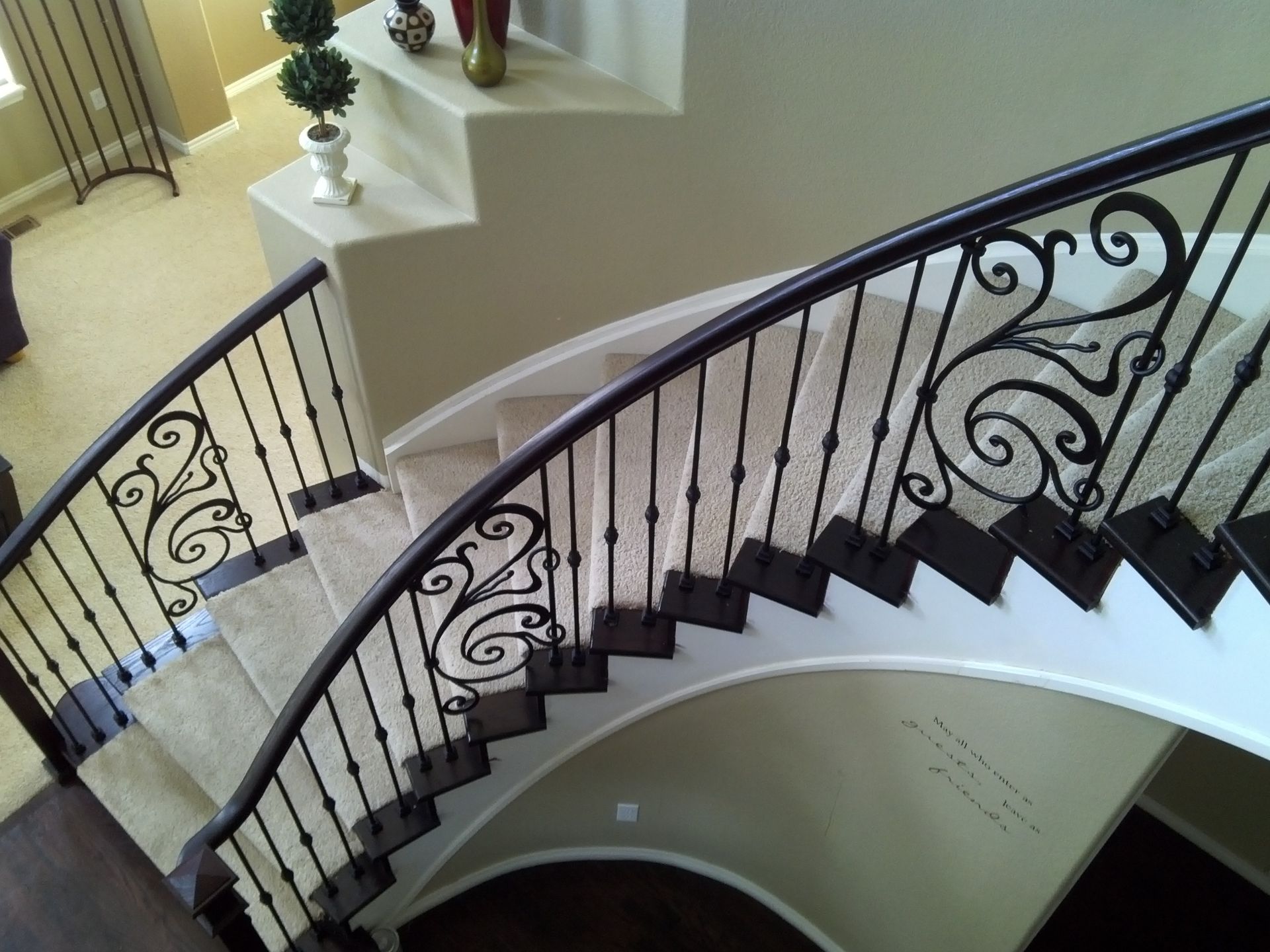 A curved staircase with a wrought iron railing in a house