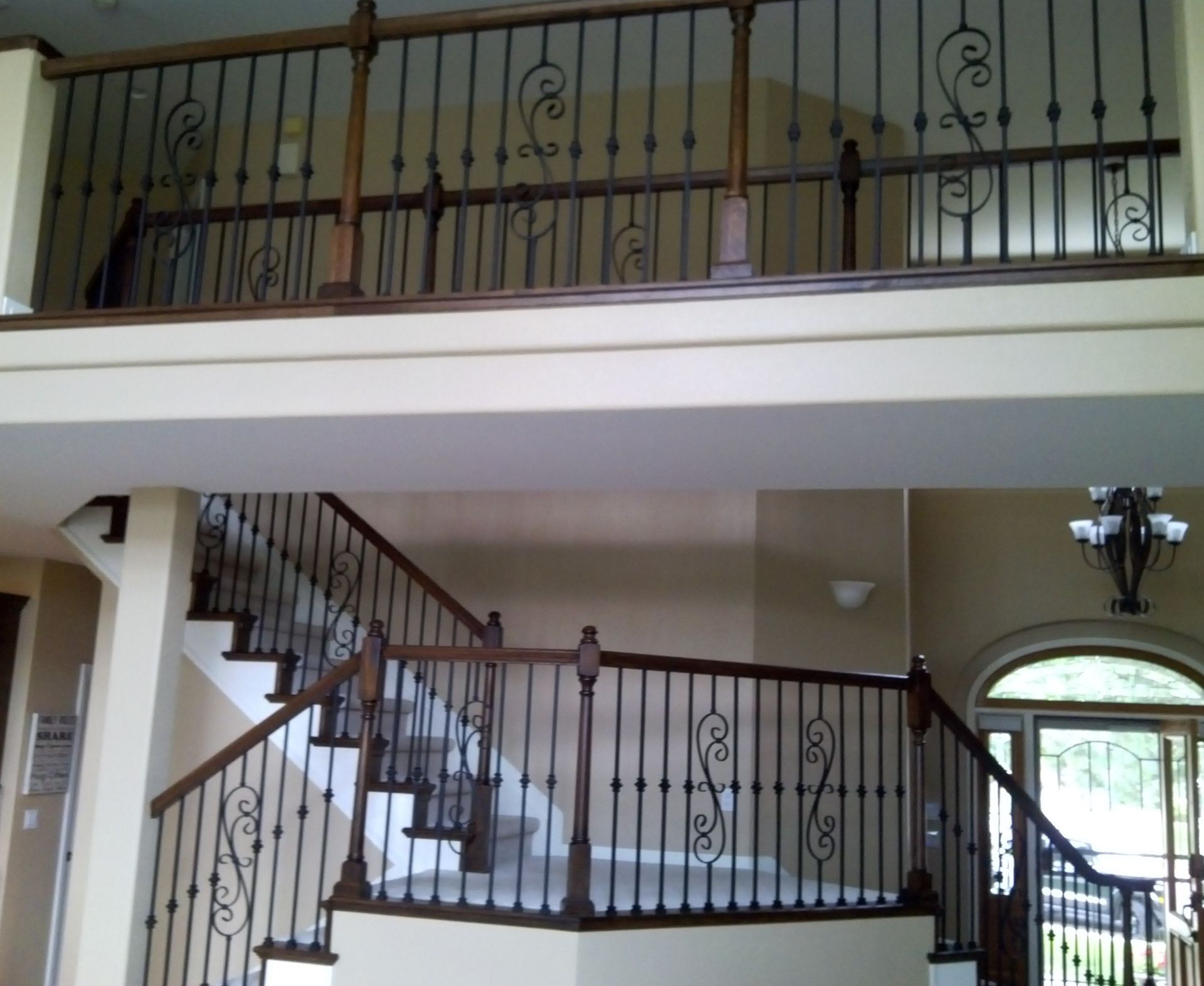 A staircase in a house with a wrought iron railing