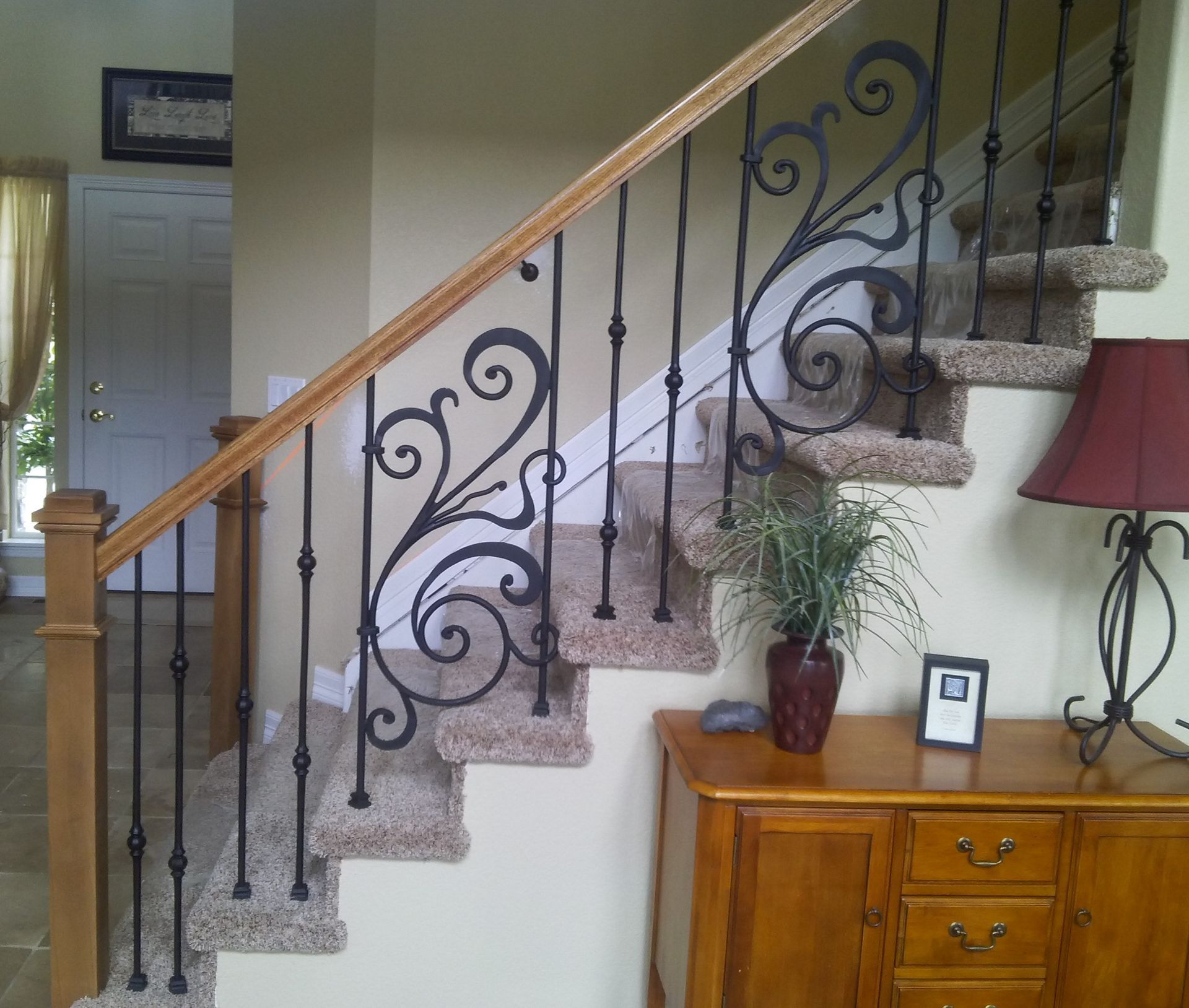 A staircase with a wrought iron railing and carpeted steps