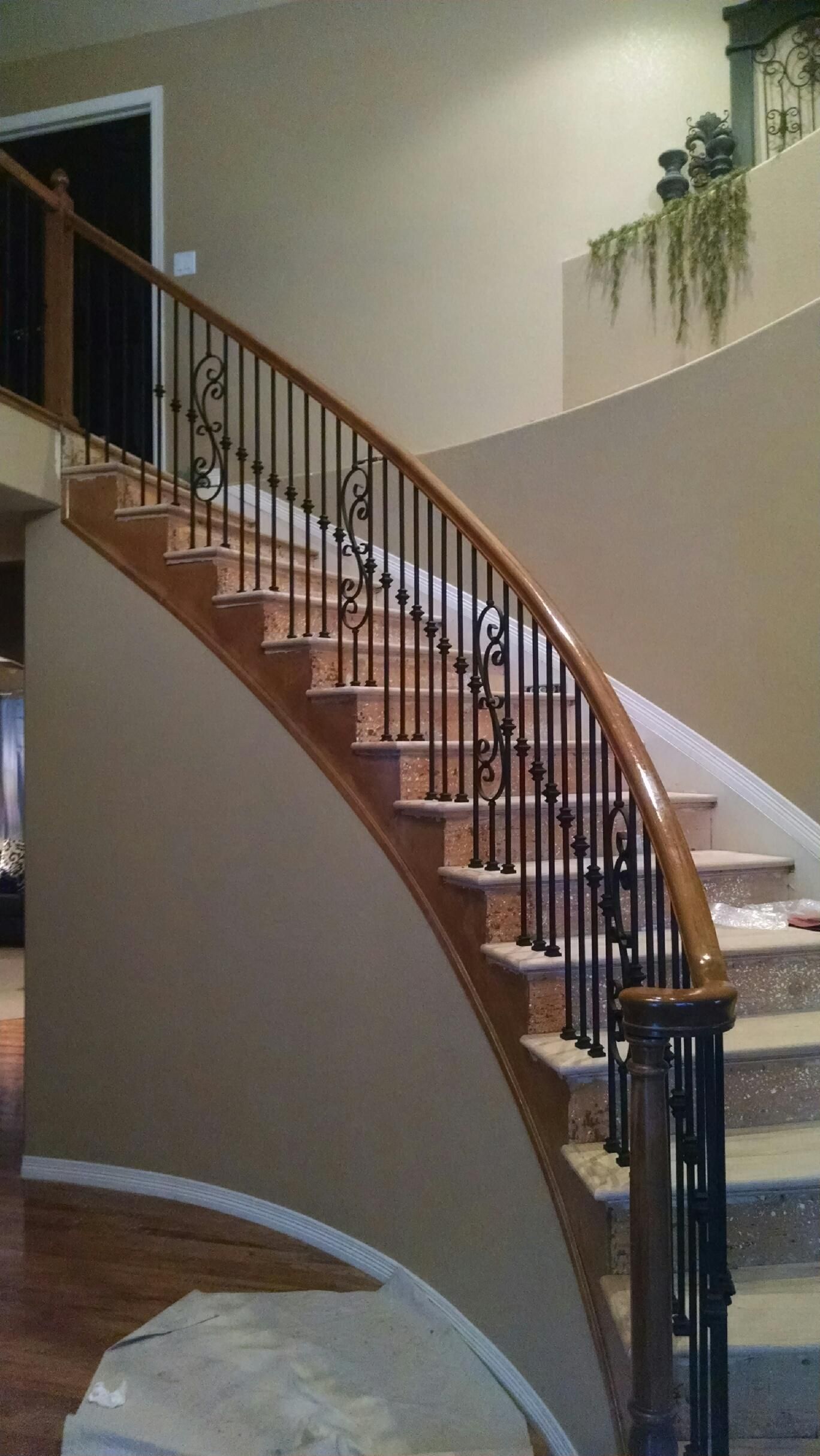 A curved staircase with a wrought iron railing in a house