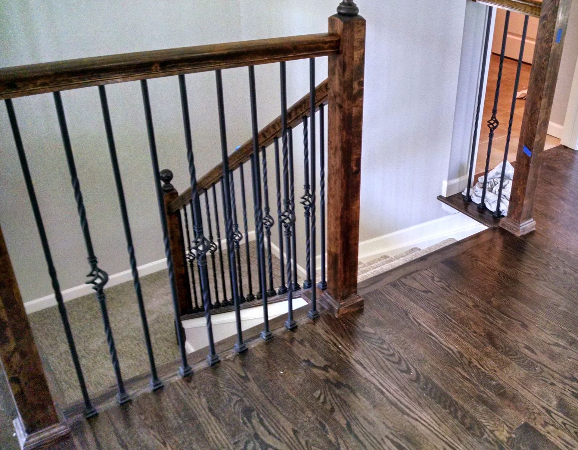 A wooden staircase with a wrought iron railing in a house.