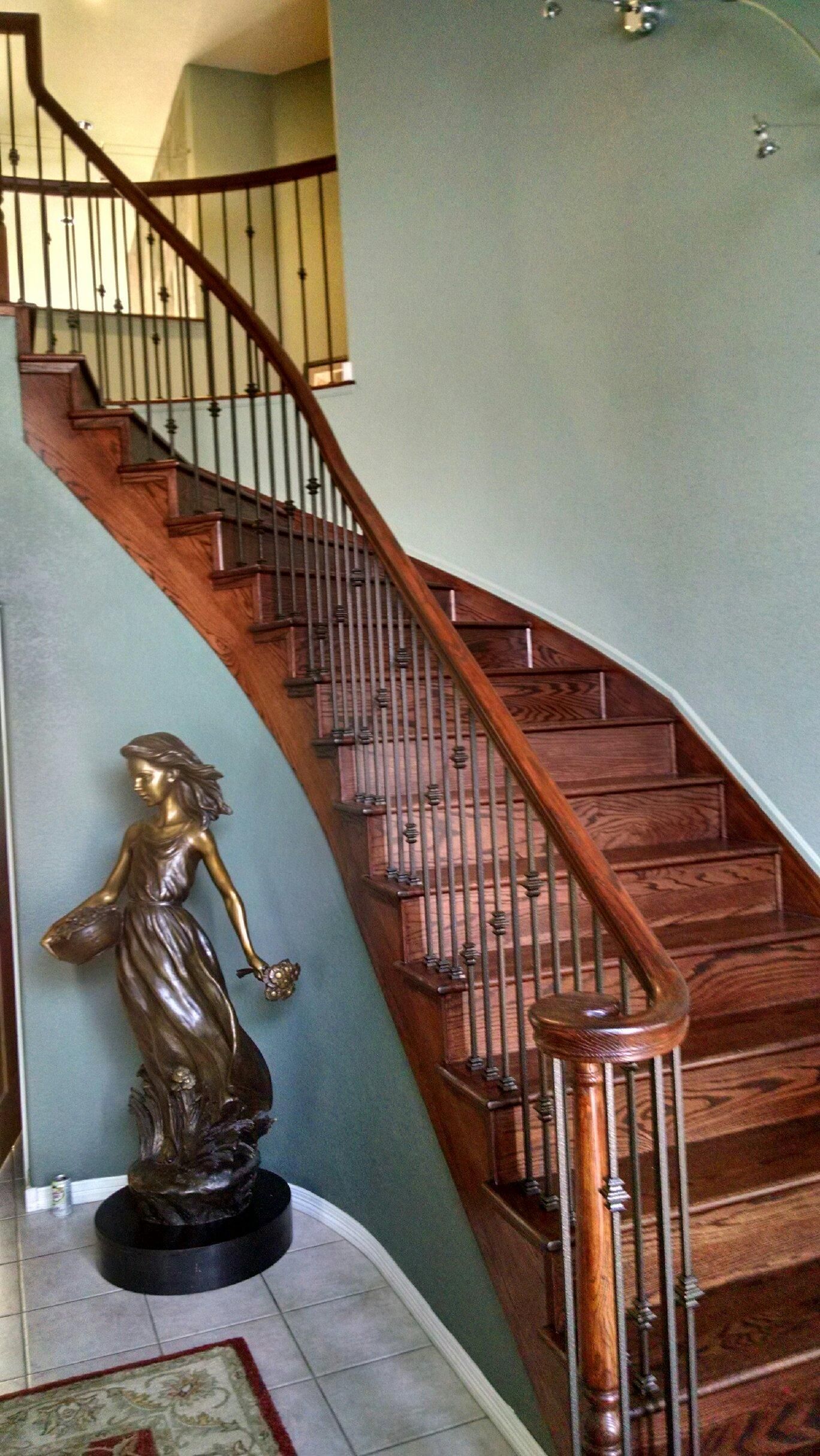 A staircase with a statue of a woman on the bottom of it.