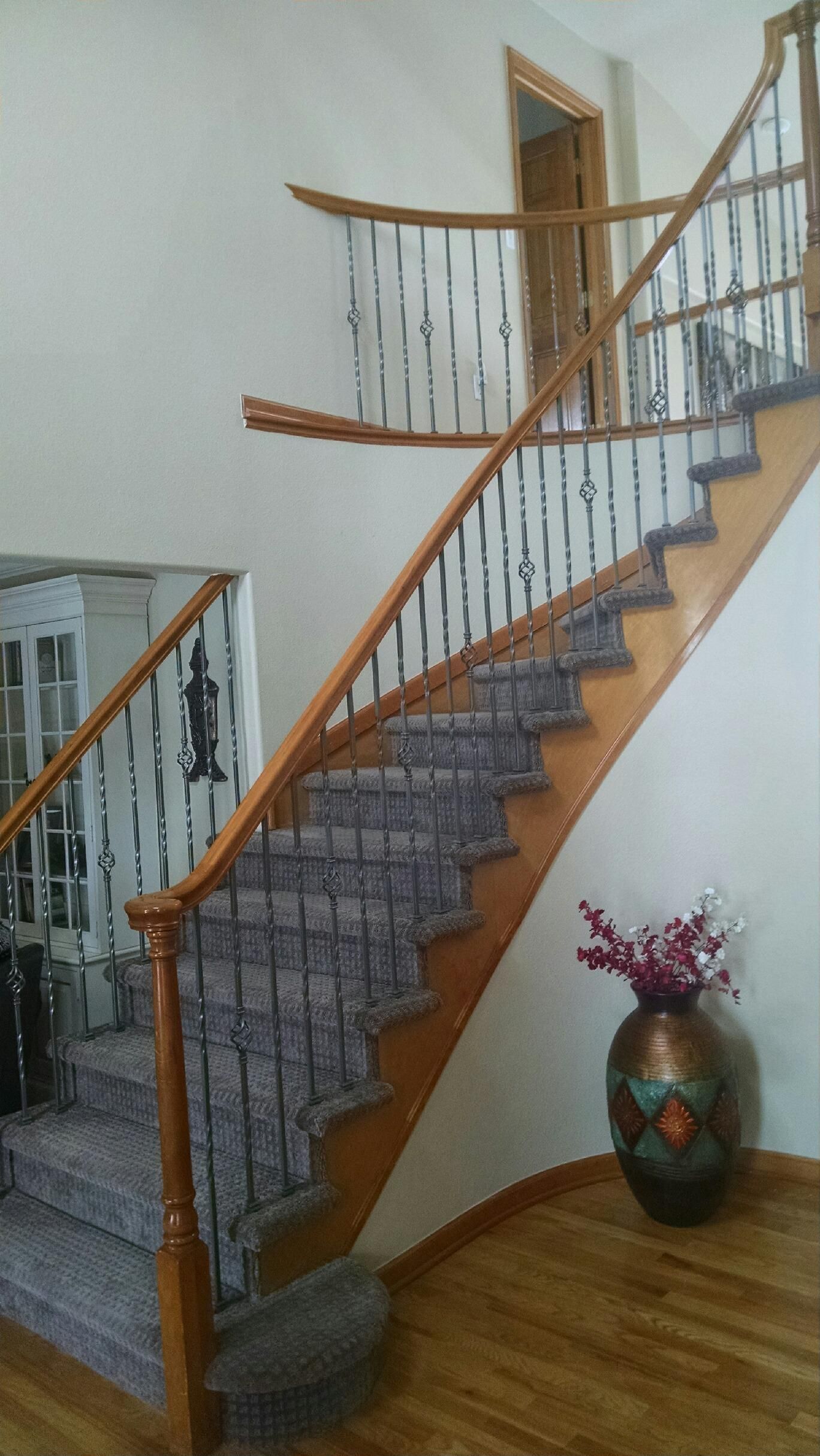 A staircase with a vase of flowers on the side of it.