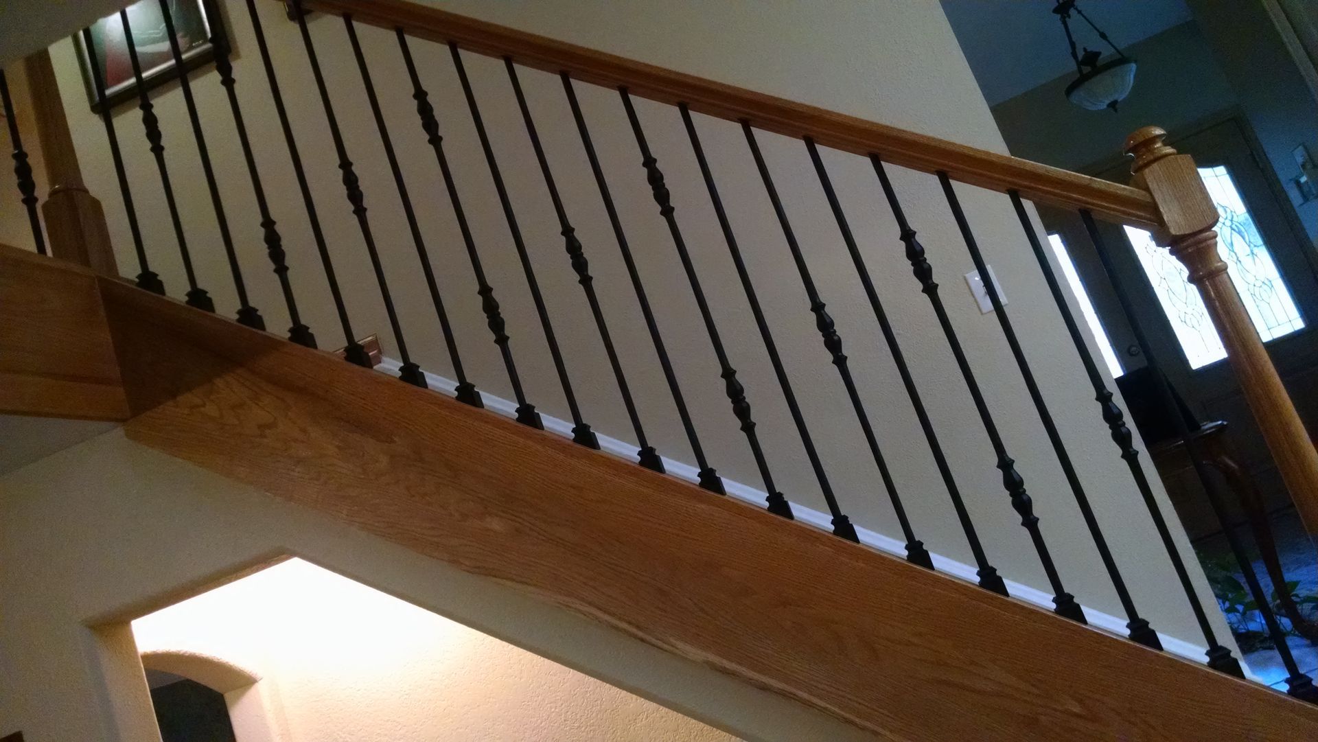 A wooden staircase with a black railing in a house