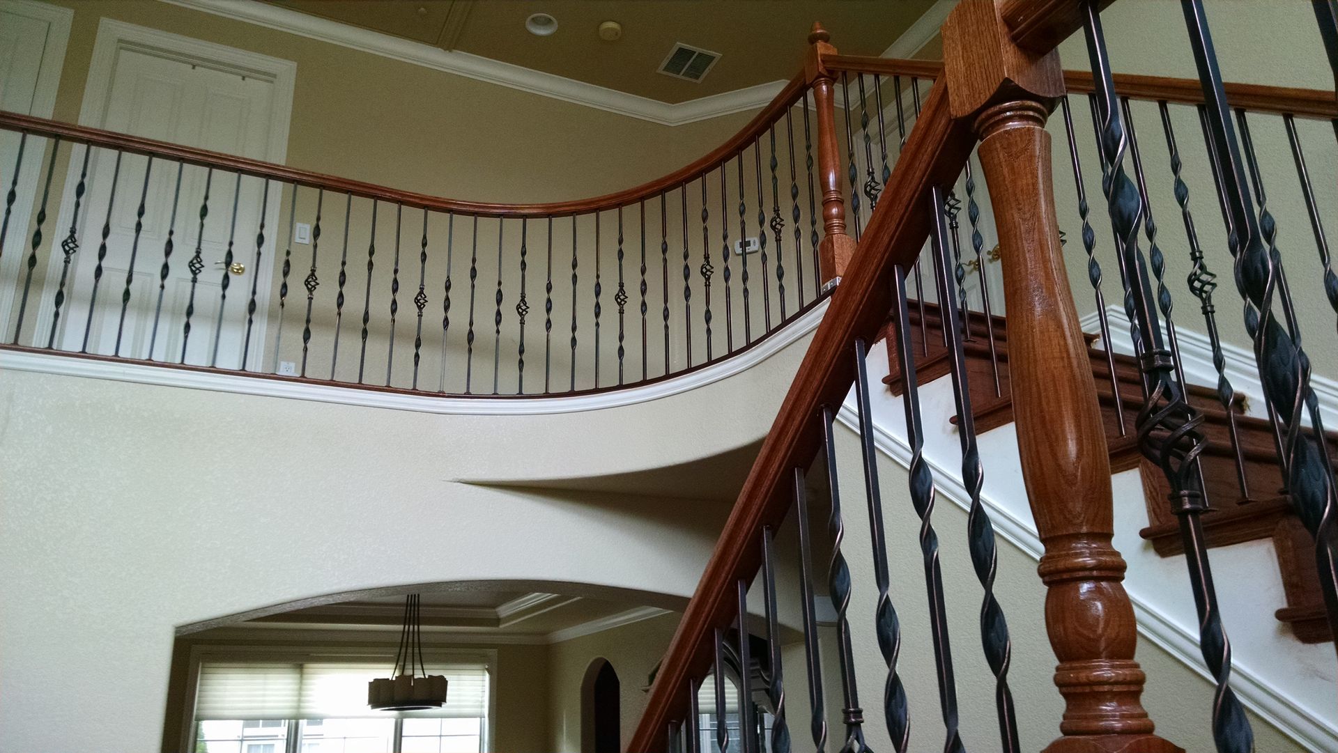 A wooden staircase with a wrought iron railing in a house
