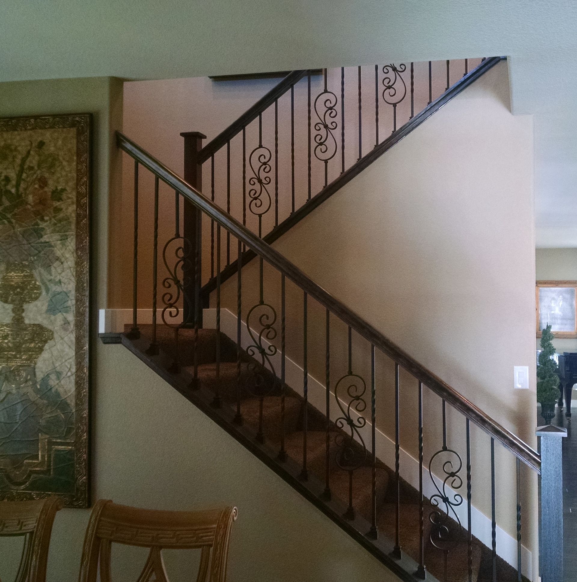 A staircase with a wrought iron railing in a house