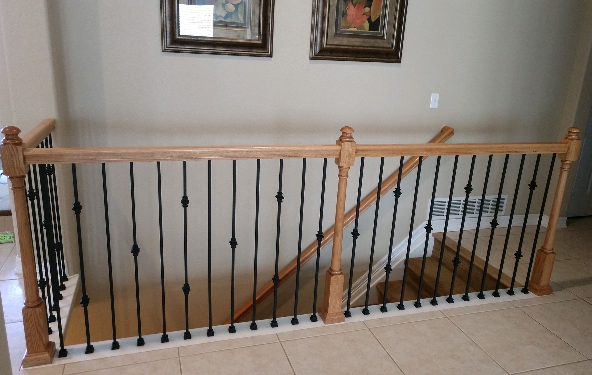 A staircase with a wooden railing and a wrought iron railing