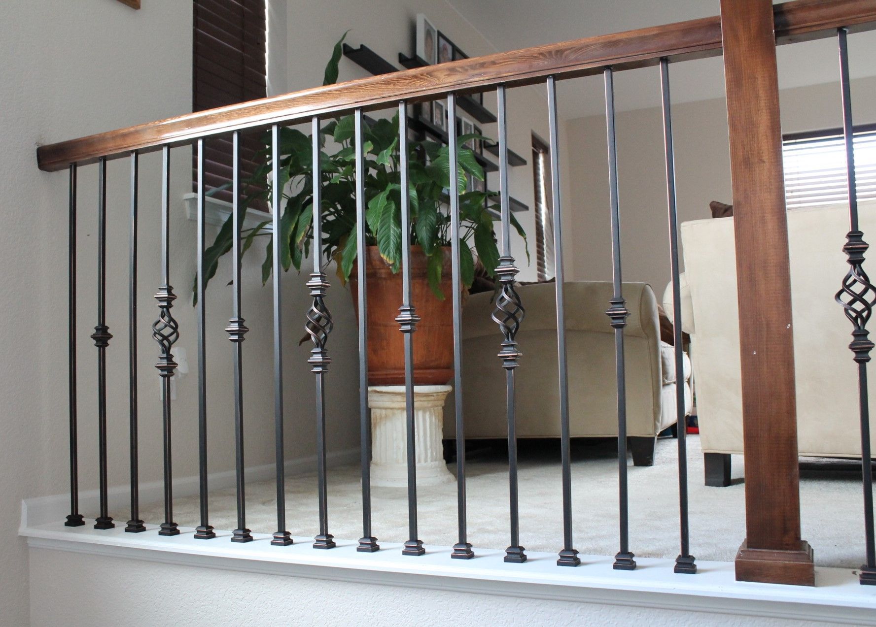 A staircase with a wrought iron railing and wooden handrail