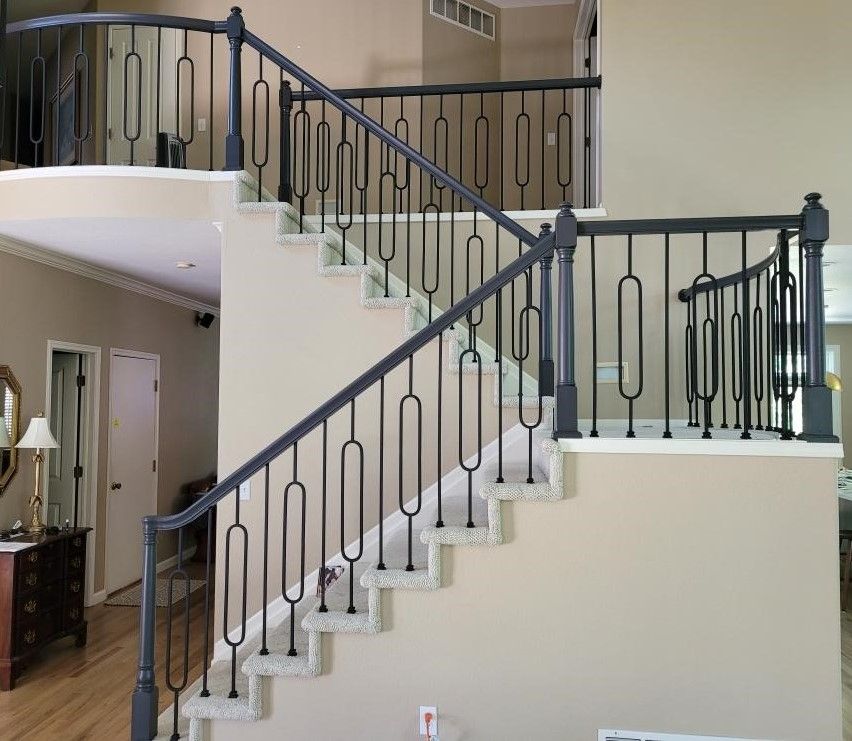 A staircase with a black railing in a living room.