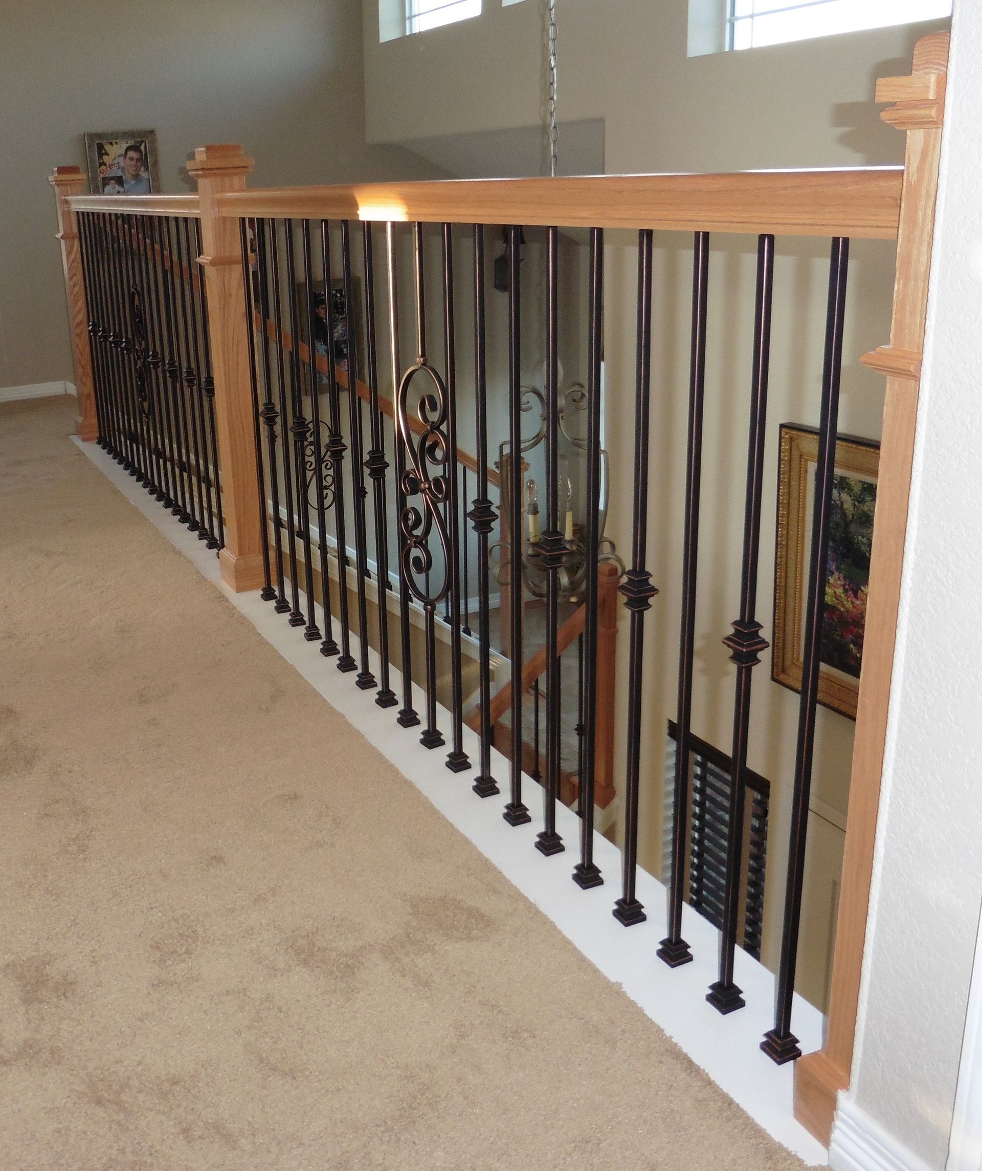 A staircase with a wrought iron railing and a wooden railing