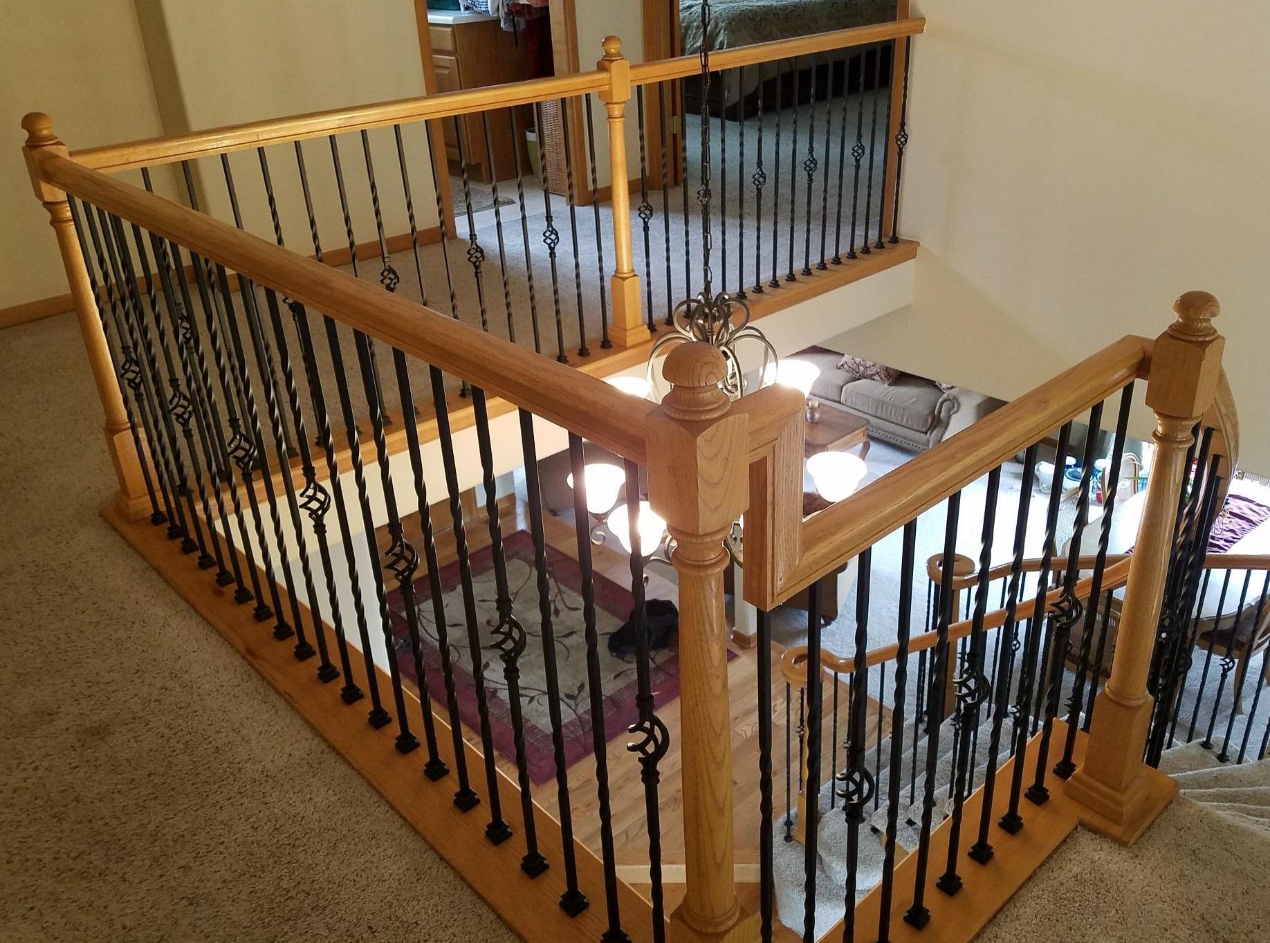 A wooden staircase with a wrought iron railing in a house.