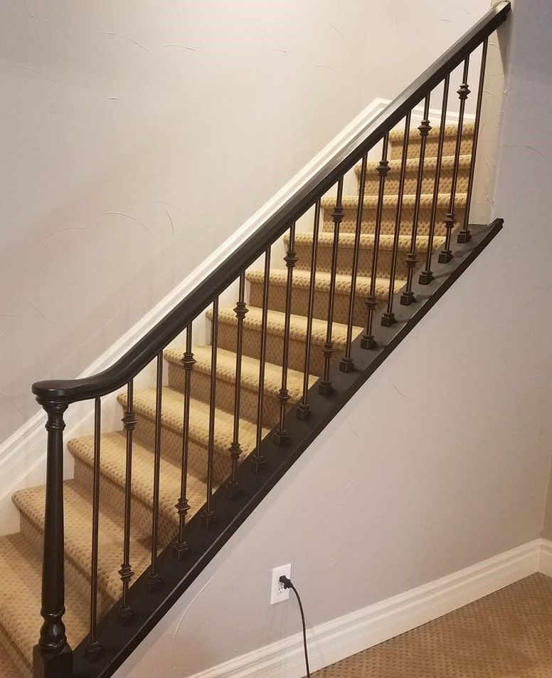 A staircase with a black railing and carpeted steps