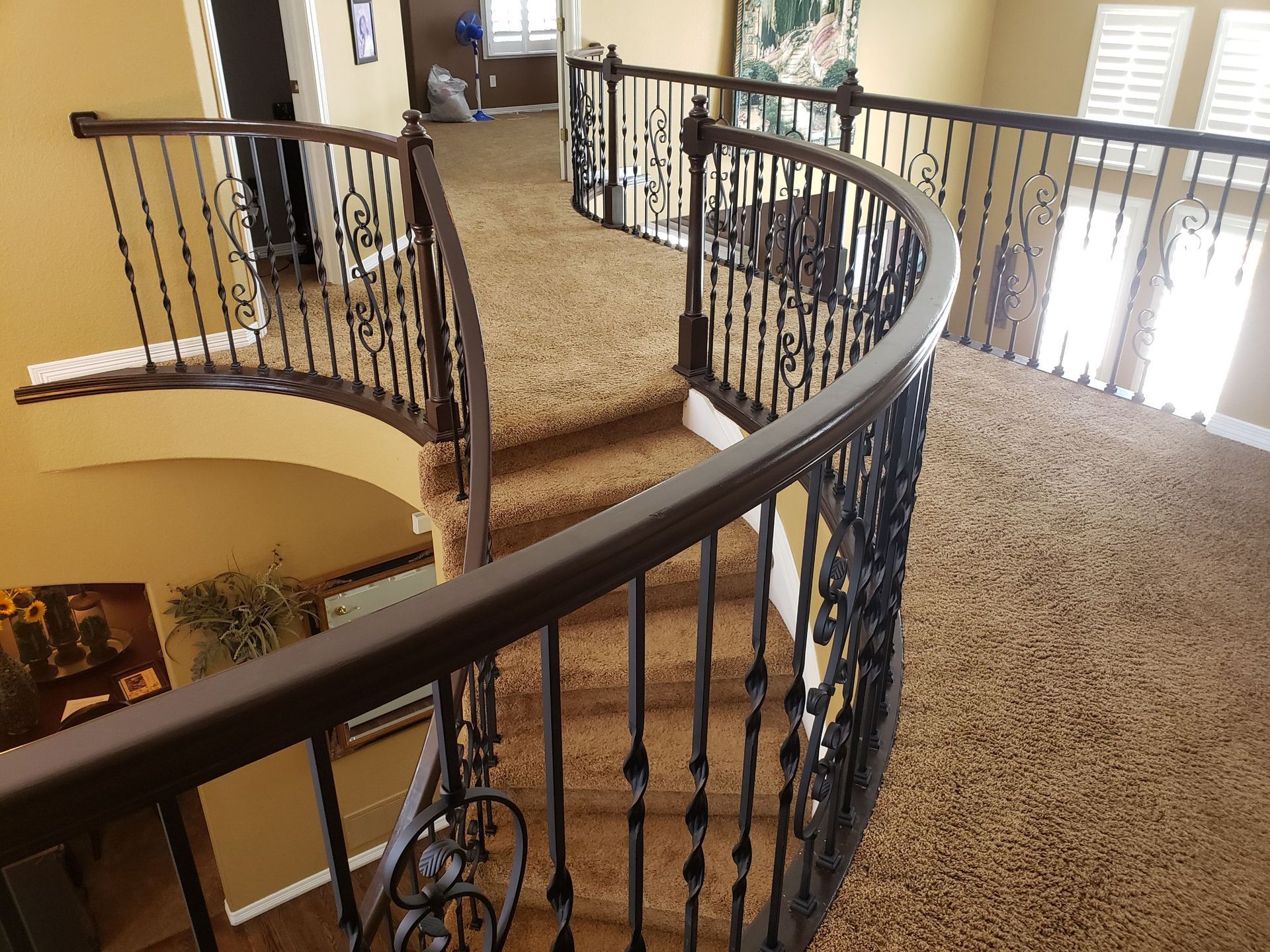 A curved staircase with a wrought iron railing in a house